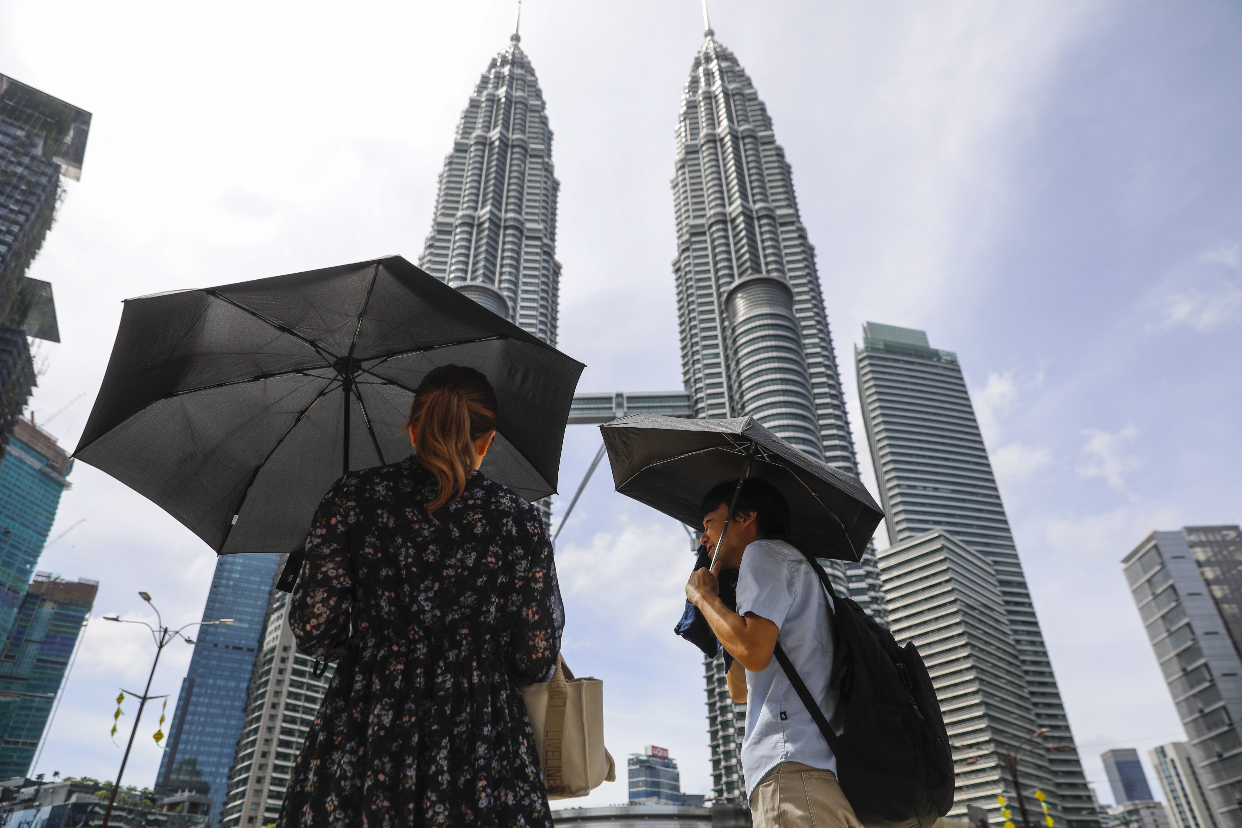 A couple use umbrellas to provide shade from the sun during a hot day in Kuala Lumpur last month. Photo: EPA-EFE