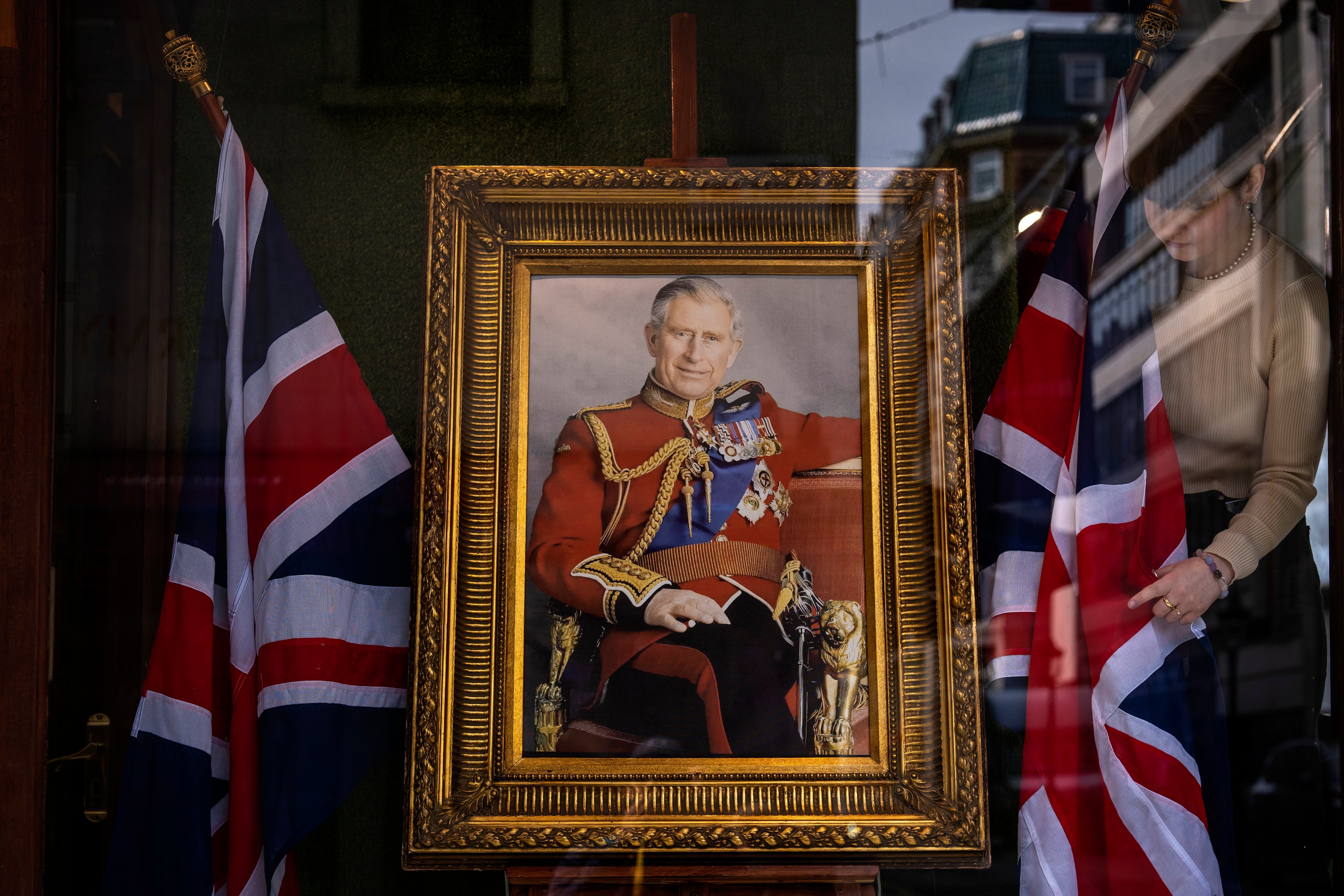 An employee arranges a shop window decorated with a painting of King Charles III in London on  Thursday, ahead of Saturday’s coronation ceremony. Photo: AP