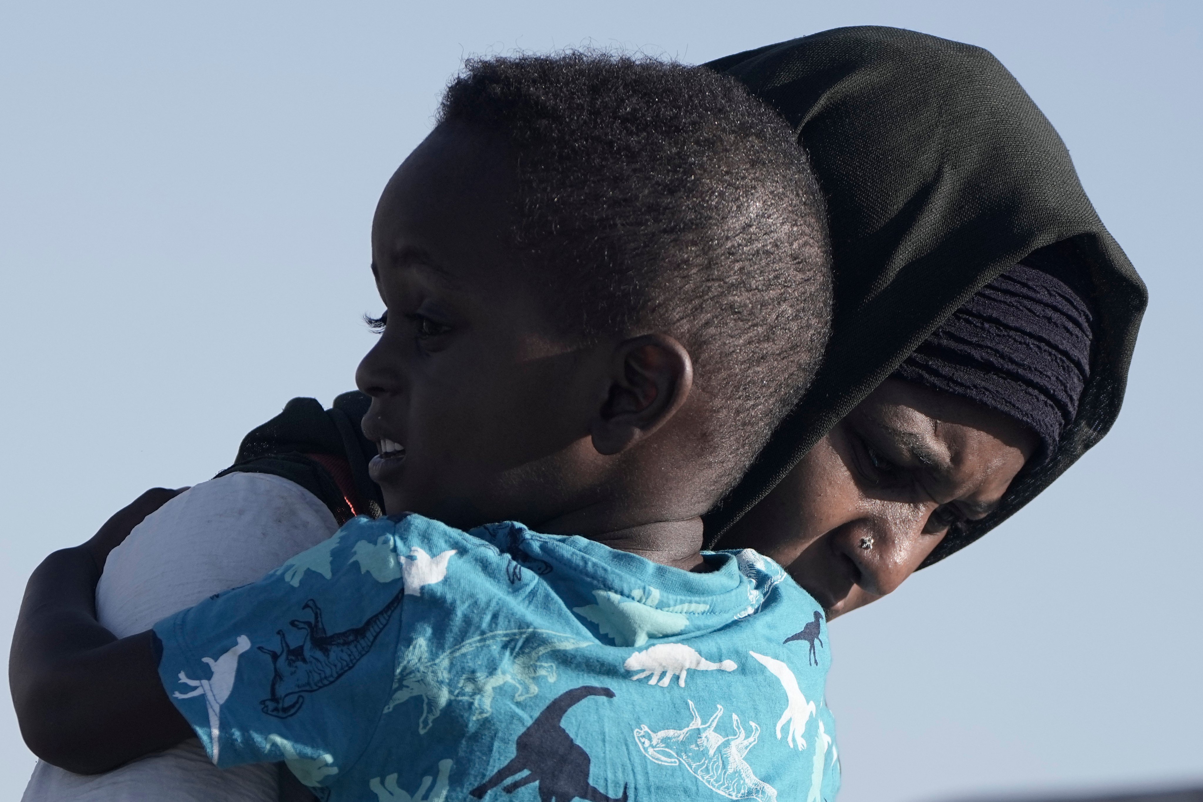 A Sudanese evacuee carries her son as they leave the USNS Brunswick at Jeddah port, Saudi Arabia. Photo: AP