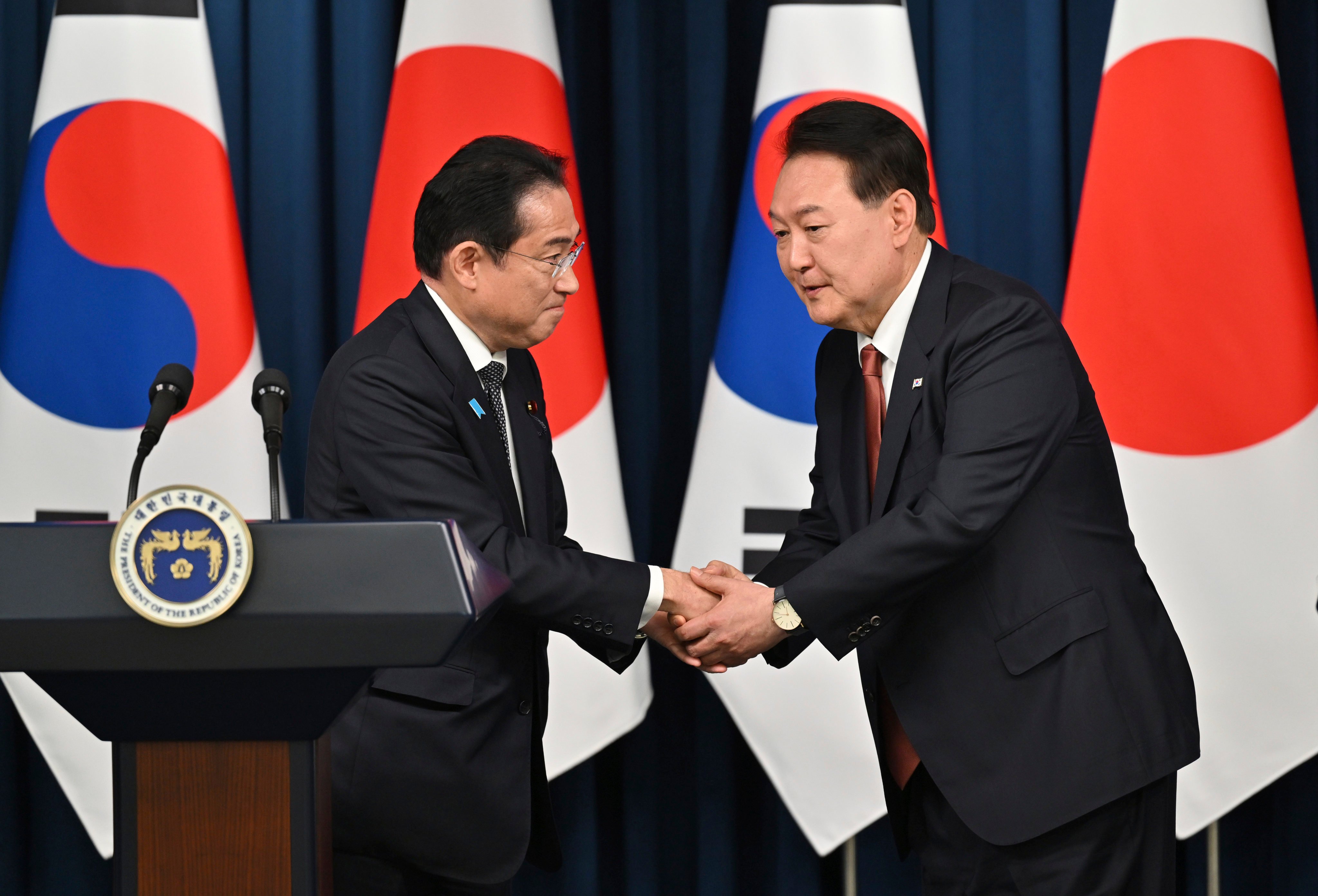 South Korean President Yoon Suk Yeol, right, shakes hands with Japanese Prime Minister Fumio Kishida during a press conference after their meeting in Seoul on Sunday, their second summit in less than two months. Photo: via AP