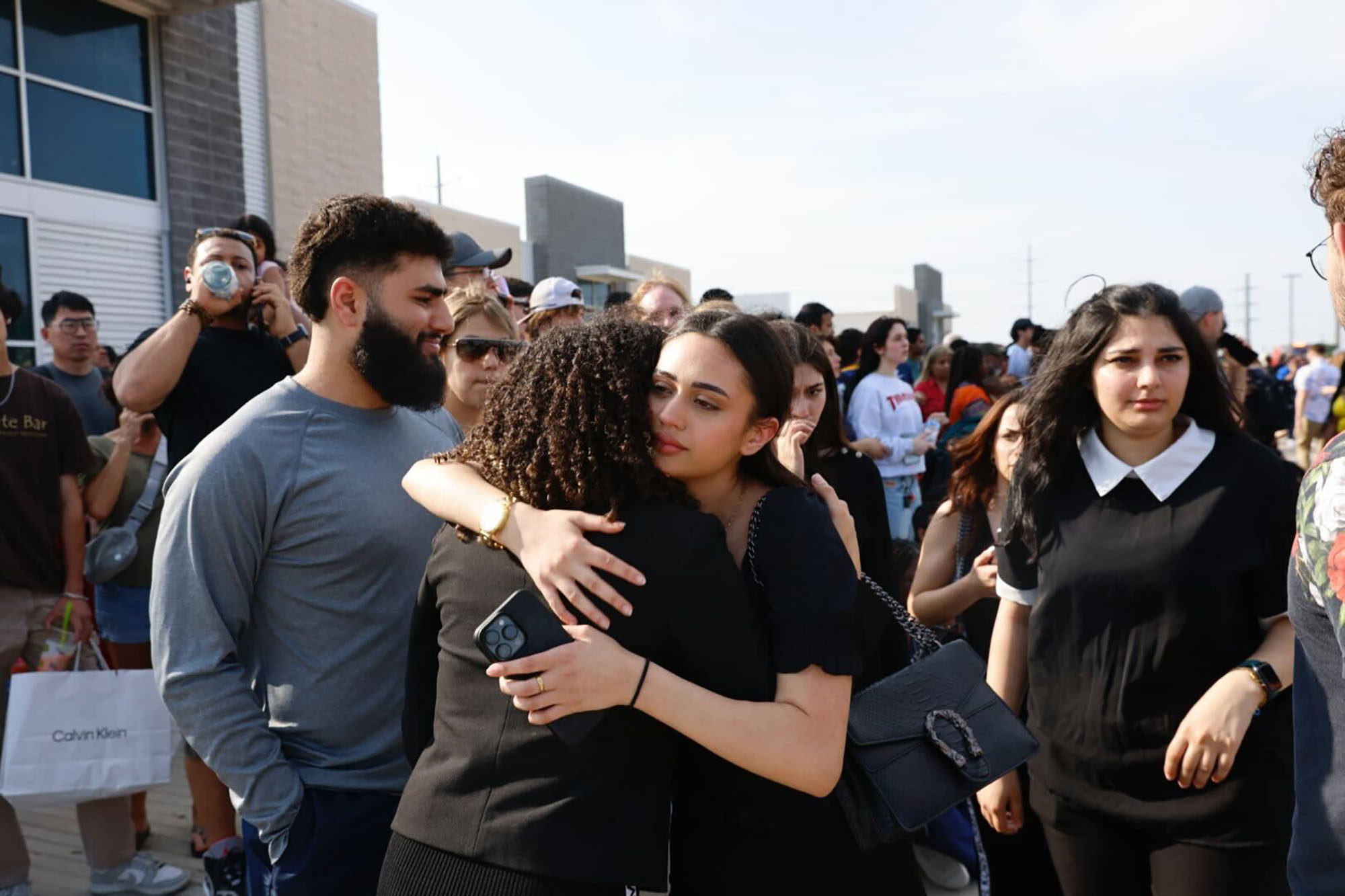 People embrace outside the Allen Premium Outlets, where authorities responded to reports of an active shooter on Saturday, May 6, 2023, in Allen, Texas. Photo: TNS