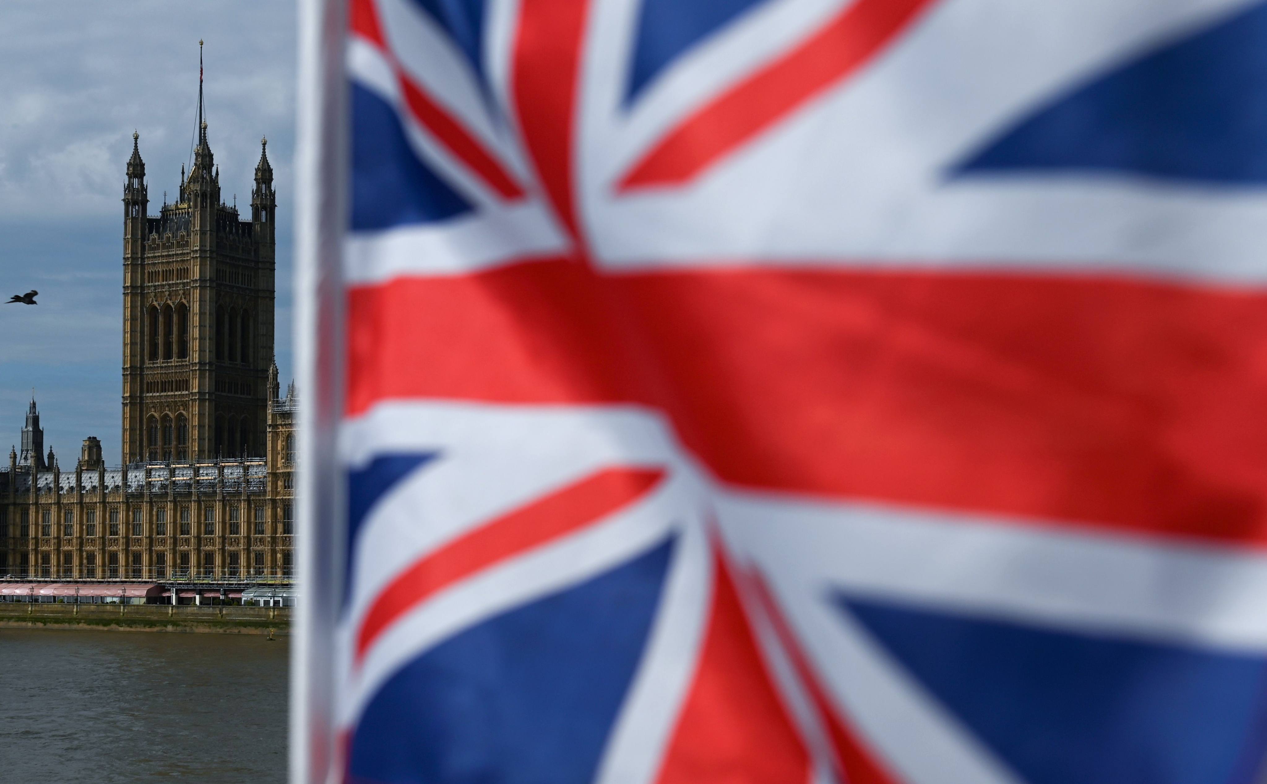 The Palace of Westminster, housing the British houses of Parliament, is seen from Westminster Bridge with a Union flag in the foreground, in central London on August 28, 2019. Photo: AFP