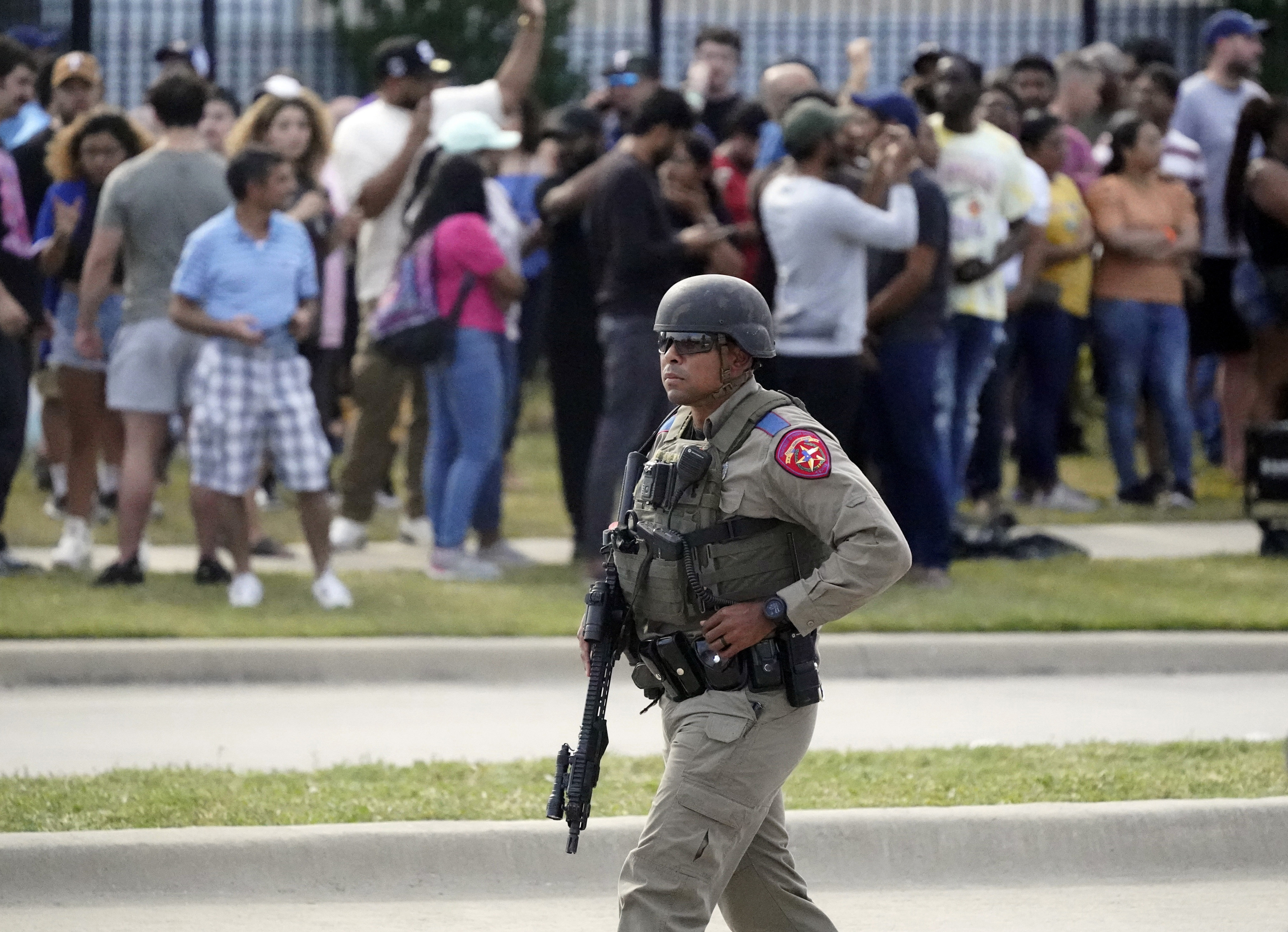 A law enforcement officer at the scene as people are evacuated from a shopping centre where a shooting occurred Saturday, in Allen, Texas. Photo: AP