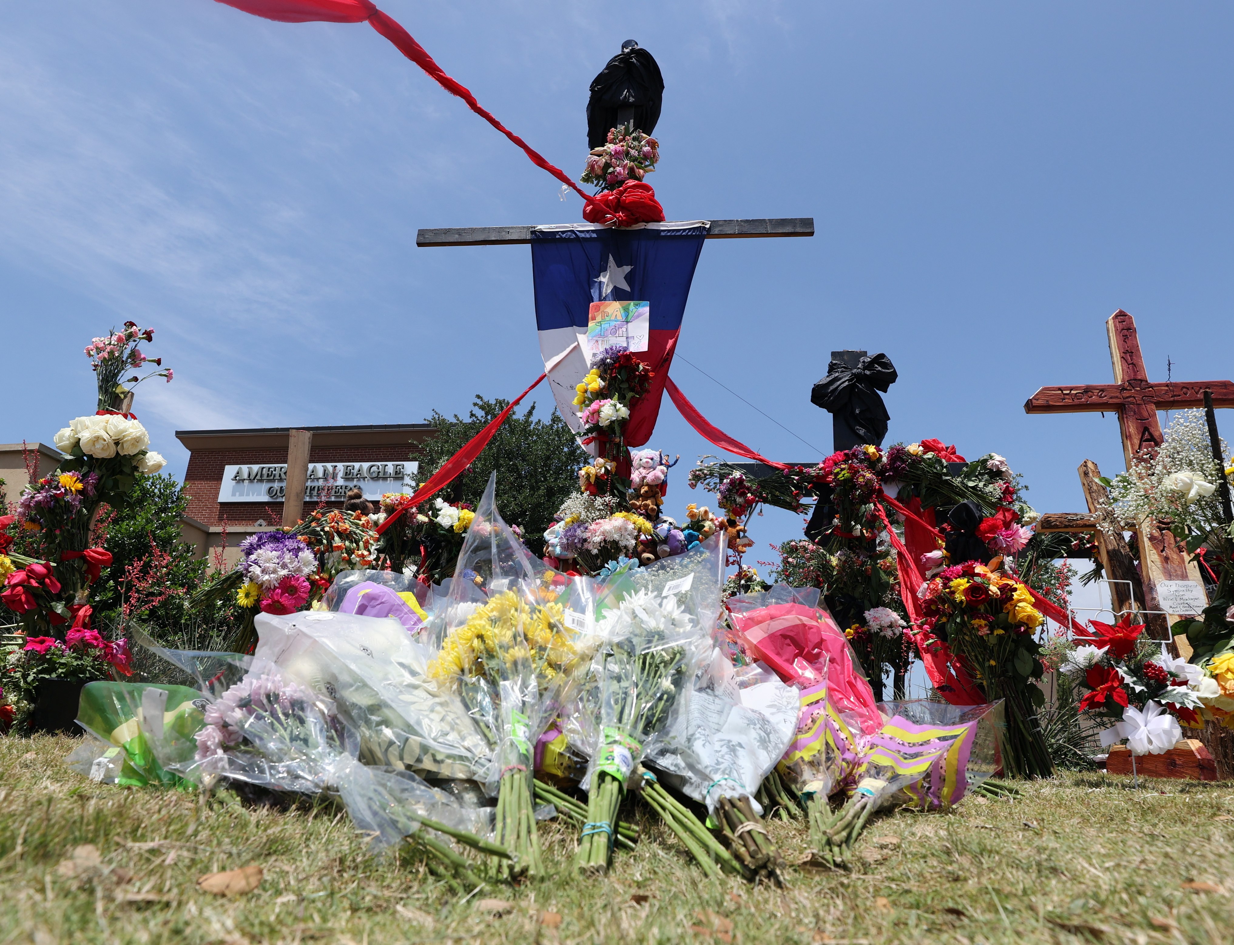 Flowers are placed in front of a cross at a vigil in front at the Allen Premium Outlets on Monday in remembrance of the victims of a mass shooting at the Texas mall. Photo: EPA-EFE