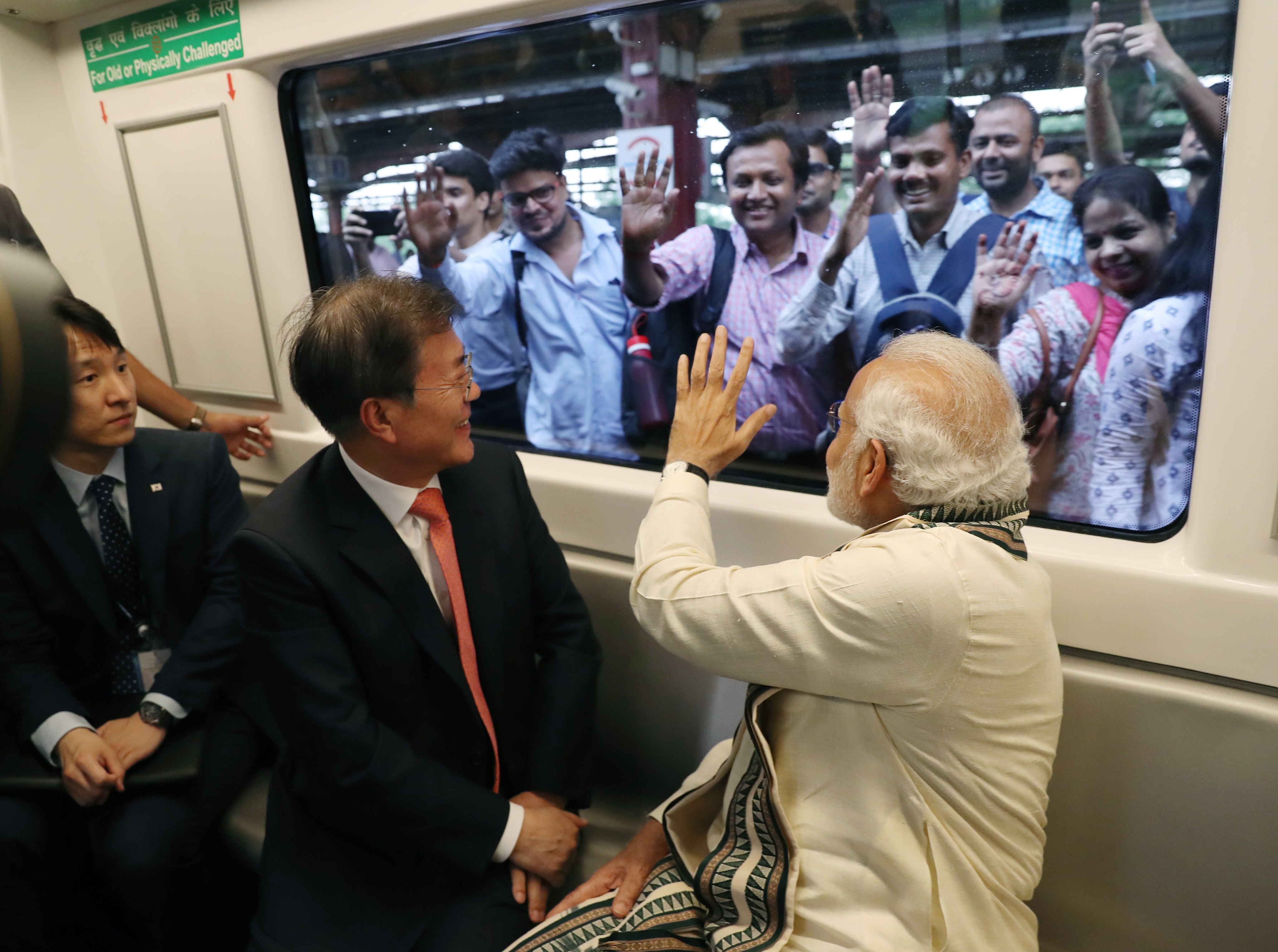 South Korea’s then president Moon Jae-in and Indian Prime Minister Narendra Modi greet onlookers during their subway ride to the Samsung Electronics factory in Uttar Pradesh, northern India, on July 9, 2018. South Korean firms are increasingly looking to India as a target for investment and expansion. Photo: EPA-EFE