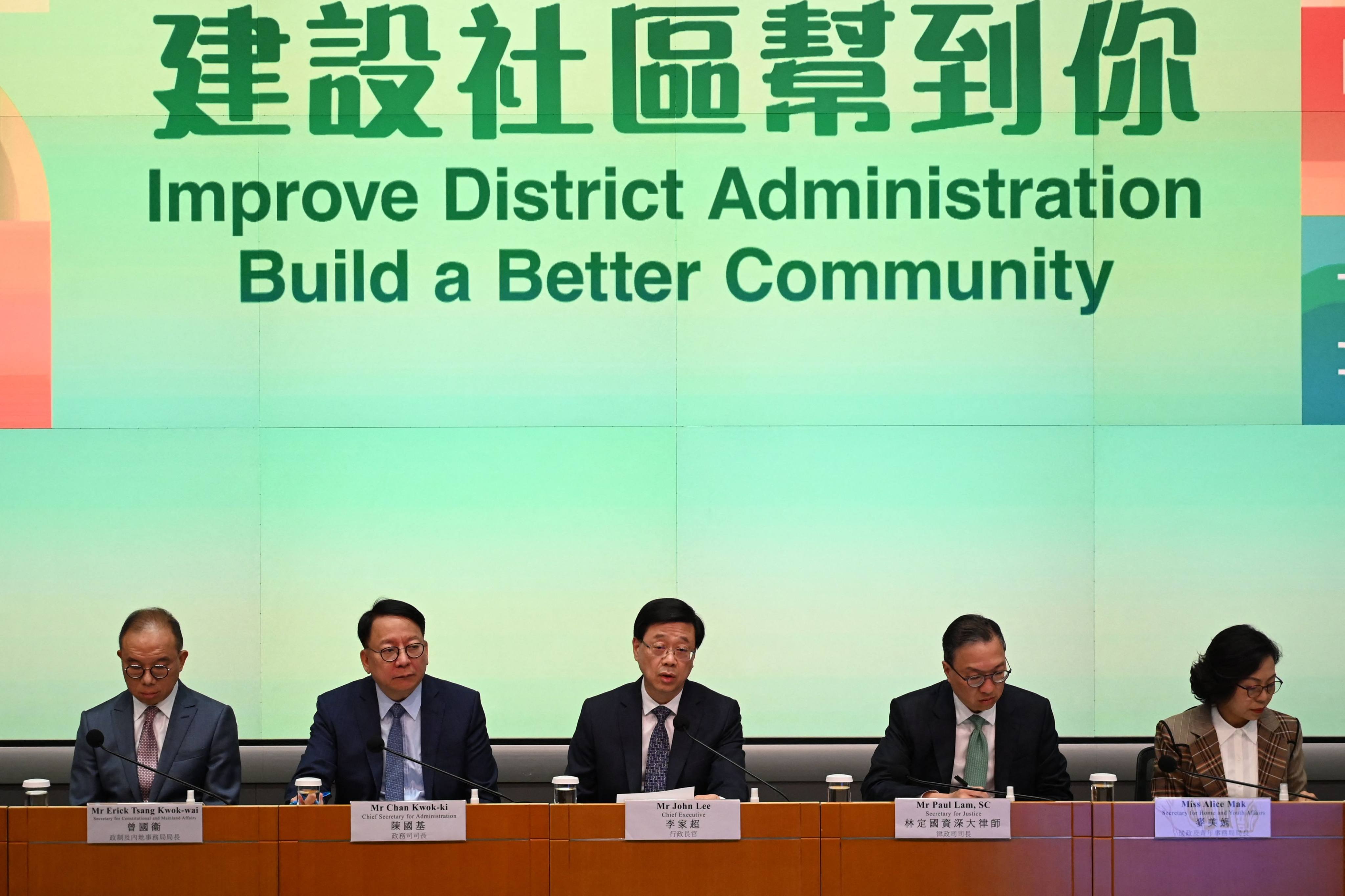 Hong Kong Chief Executive John Lee Ka-chiu (centre) lead a team from the administration to unveil the details of the district council revamp at a press conference on May 2. Photo: AFP