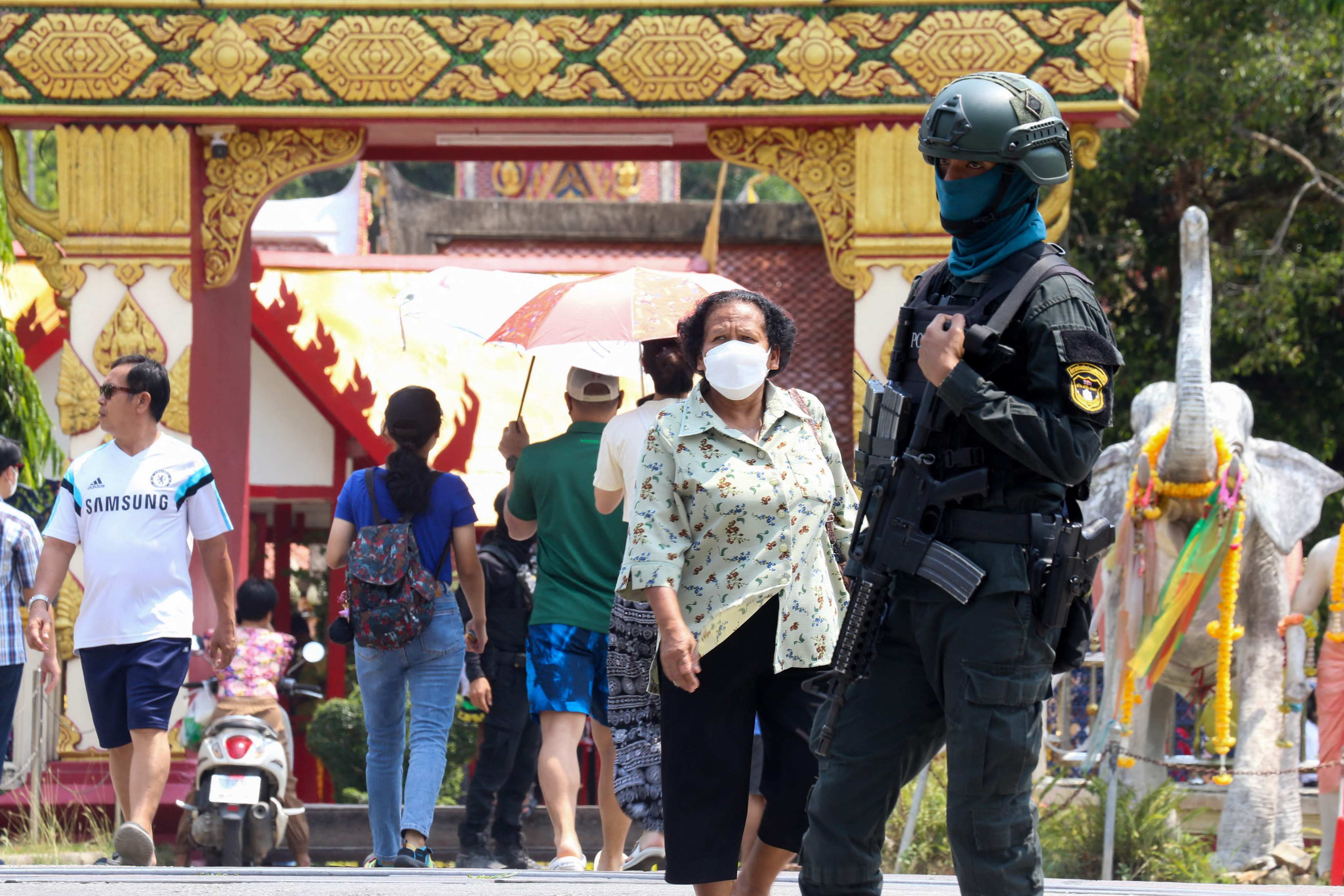 A Thai police officer stands guard as tourists visit the Chang Hai Temple in Khok Pho district, Pattani province, on April 15, 2023. Photo: AFP