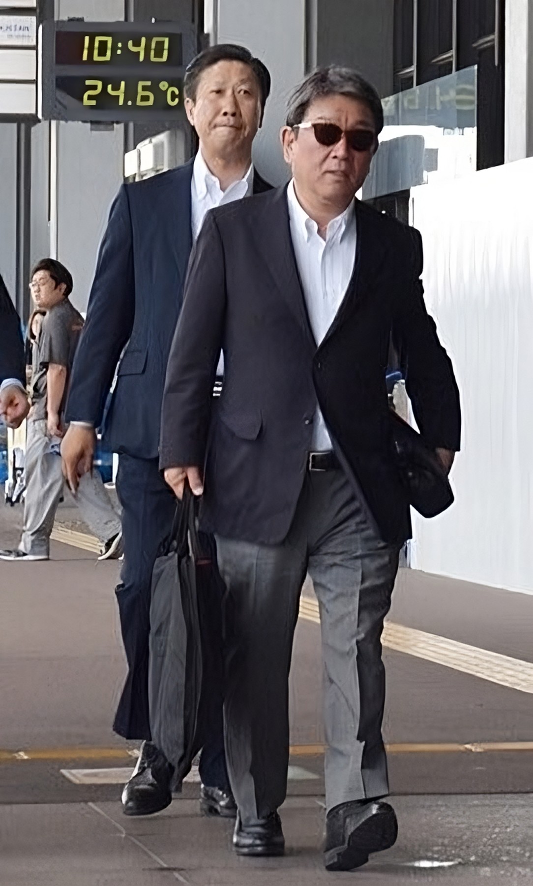 Toshimitsu Motegi was photographed in 2019 leaving Tokyo’s Haneda Airport dressed in a white jacket, open-neck shirt and sunglasses. Twitter/@hayatezamurai
