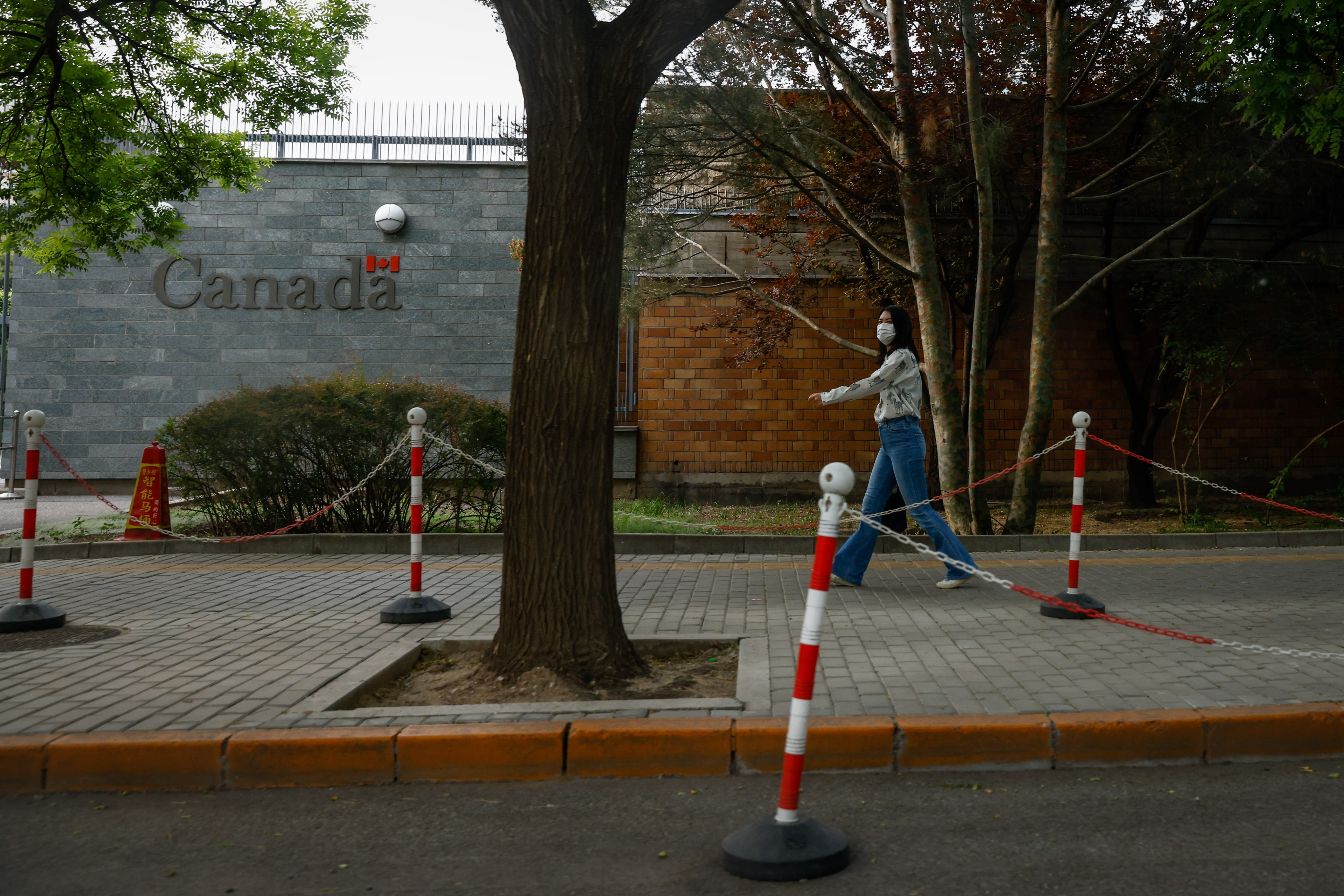 A woman walks by the Canadian embassy in Beijing on May 9. Canada and China have each expelled a diplomat from the other side. Photo: EPA-EFE 