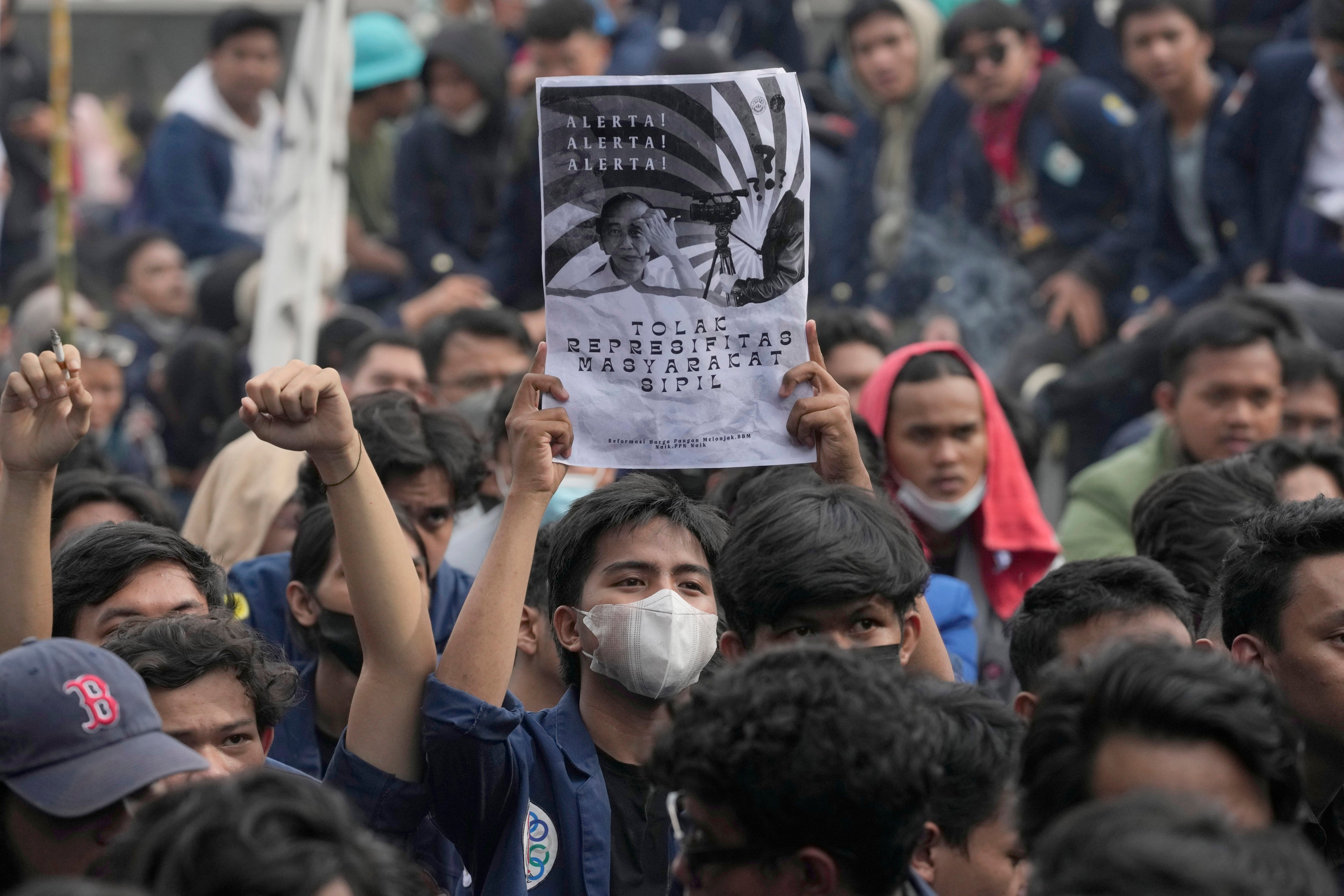 A student holds a poster with portraits of President Joko Widodo during a rally in Jakarta, Indonesia in April 2022, demanding the government stop attempts to postpone the 2024 presidential election. Photo: AP
