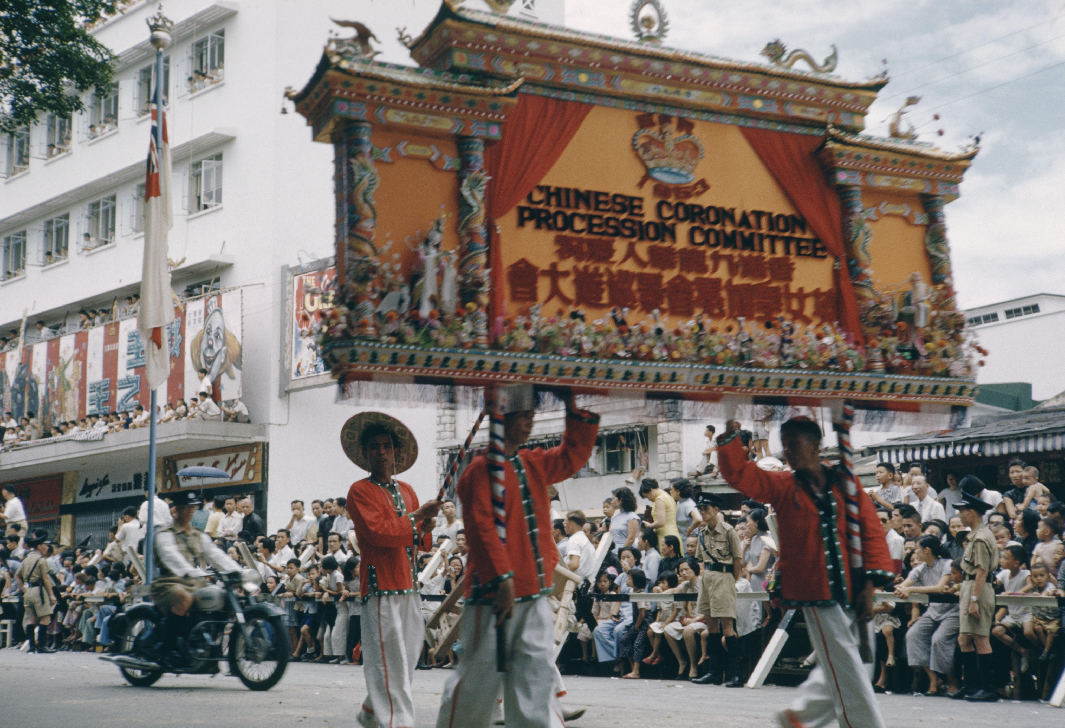 A procession in Hong Kong to celebrate the coronation of Queen Elizabeth in June 1953. The Chinese Coronation Procession Committee march by with a large sign. Photo: Getty Images