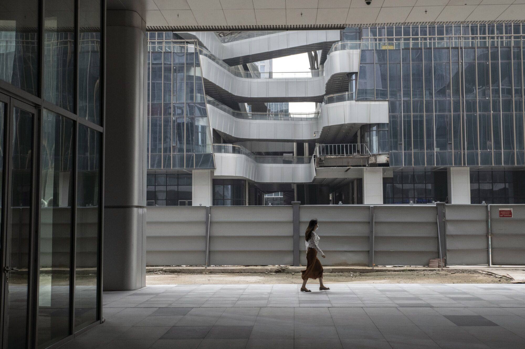 A pedestrian passes a construction site for a commercial building in the Pazhou area of Guangzhou on May 9. Mainland China has emerged as a favourite destination for commercial property investment since Beijing ended its zero-Covid policy, taking in a fifth of outbound capital from Singapore, one of the Asia-Pacific’s leading investment sources. Photo: Bloomberg
