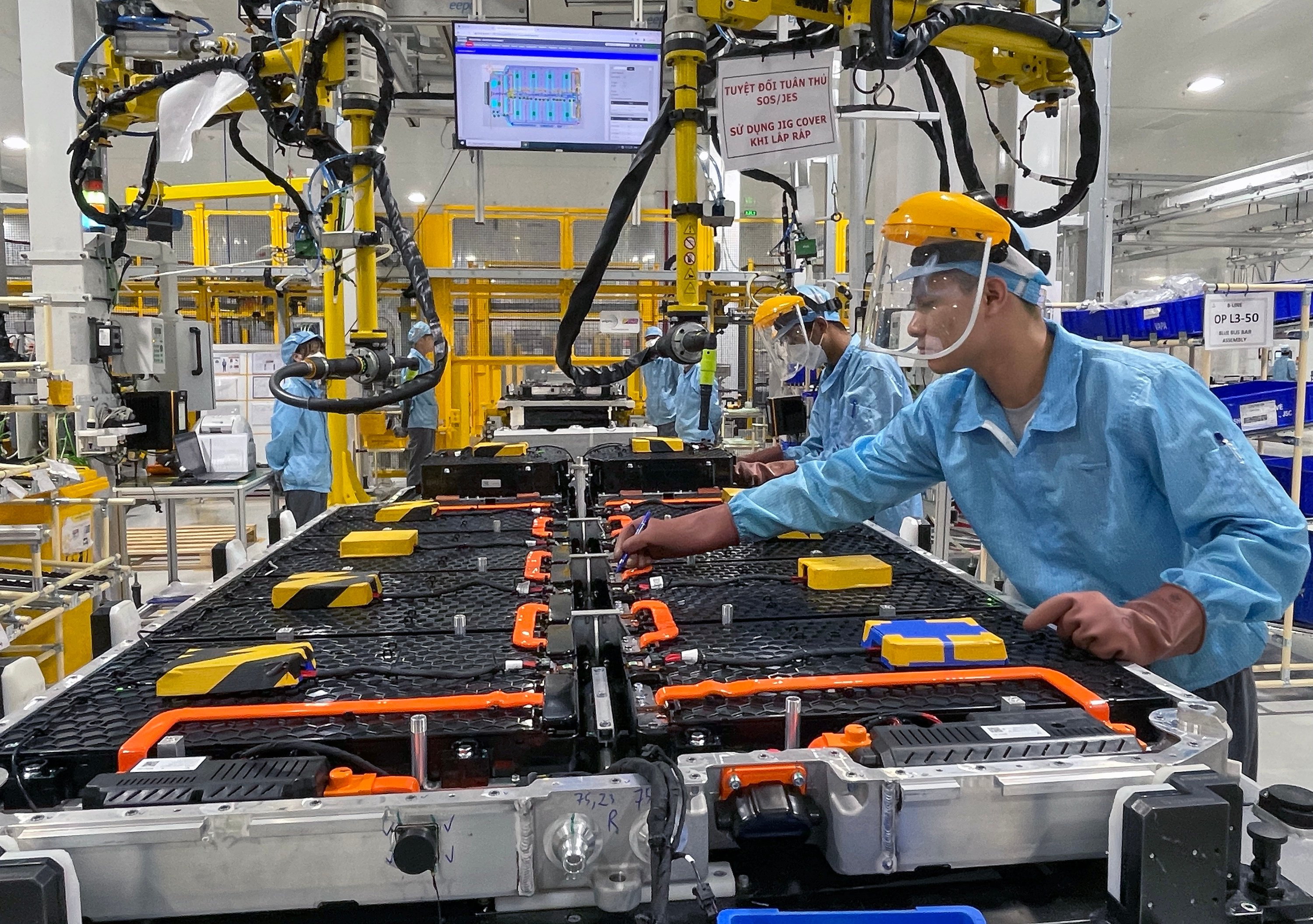 Workers oversee the robots that put together electric vehicles at the fully automated VinFast car factory in Hai Phong, Vietnam, in July 2022. Photo: Getty Images