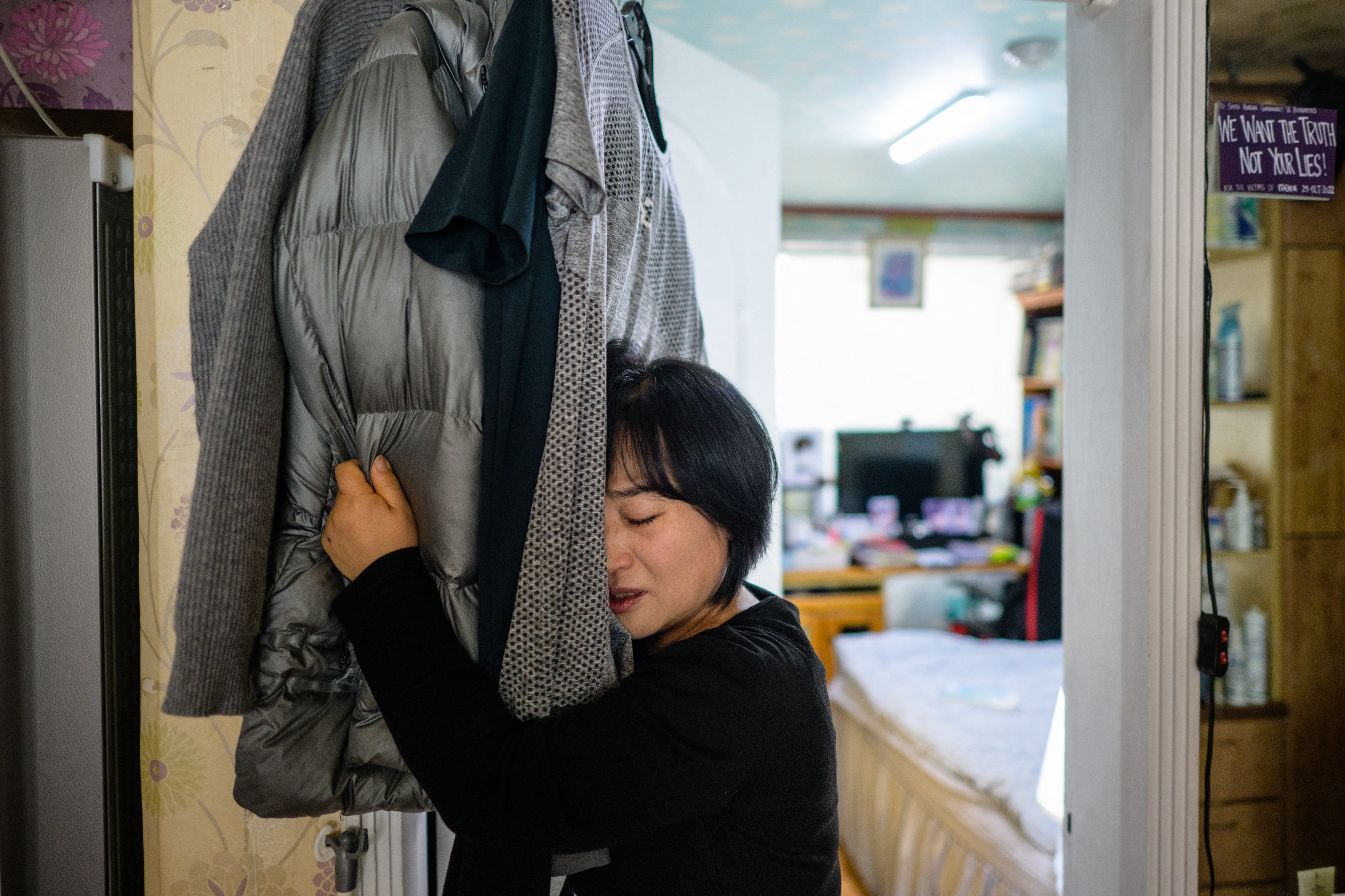 A Halloween crush victim’s mother hugs his clothes. The 2022 tragedy exposed South Korea’s mental healthcare shortcomings. Photo: AFP