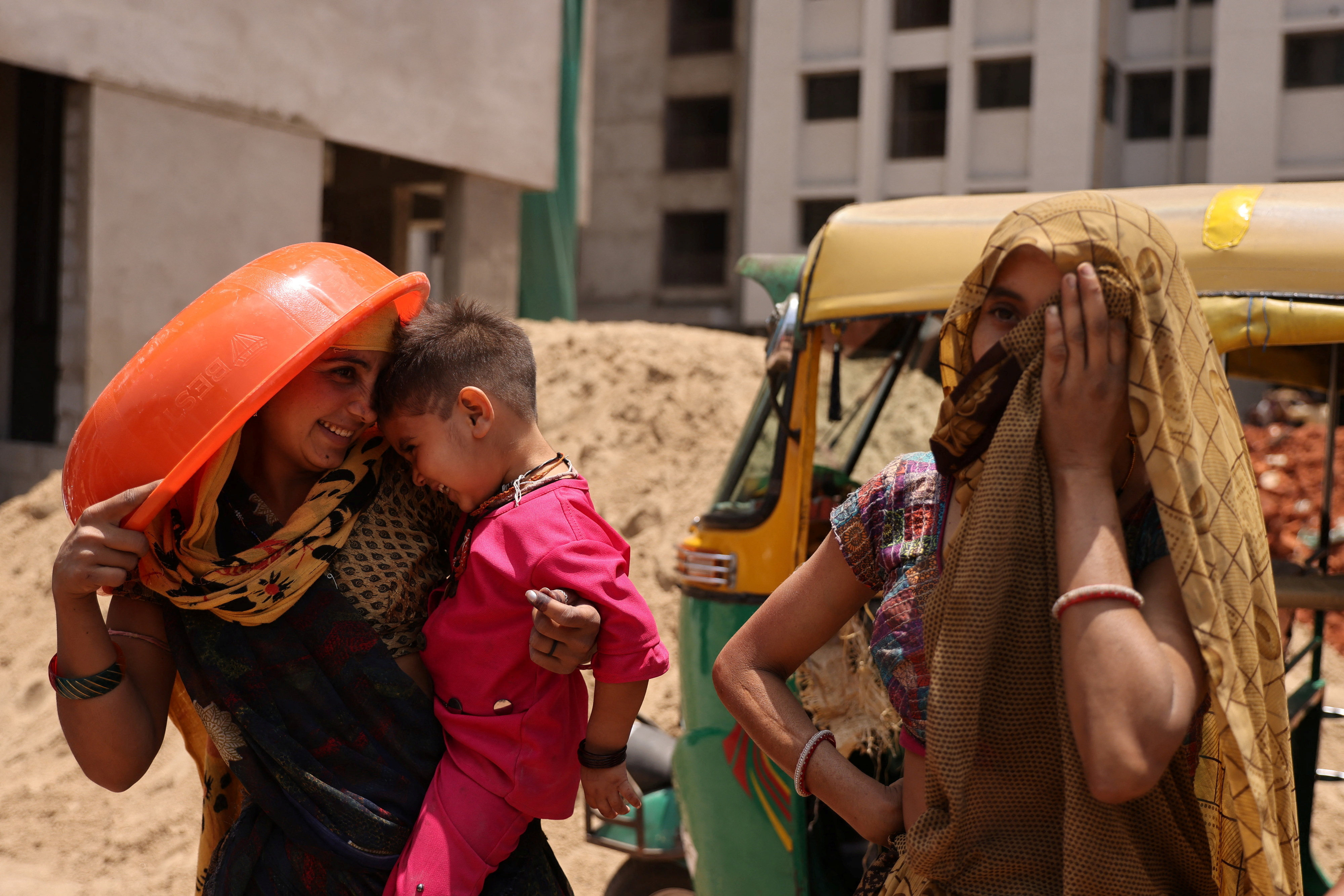 Women take shelter from the sun at a construction site in Ahmedabad, India. Photo: Reuters