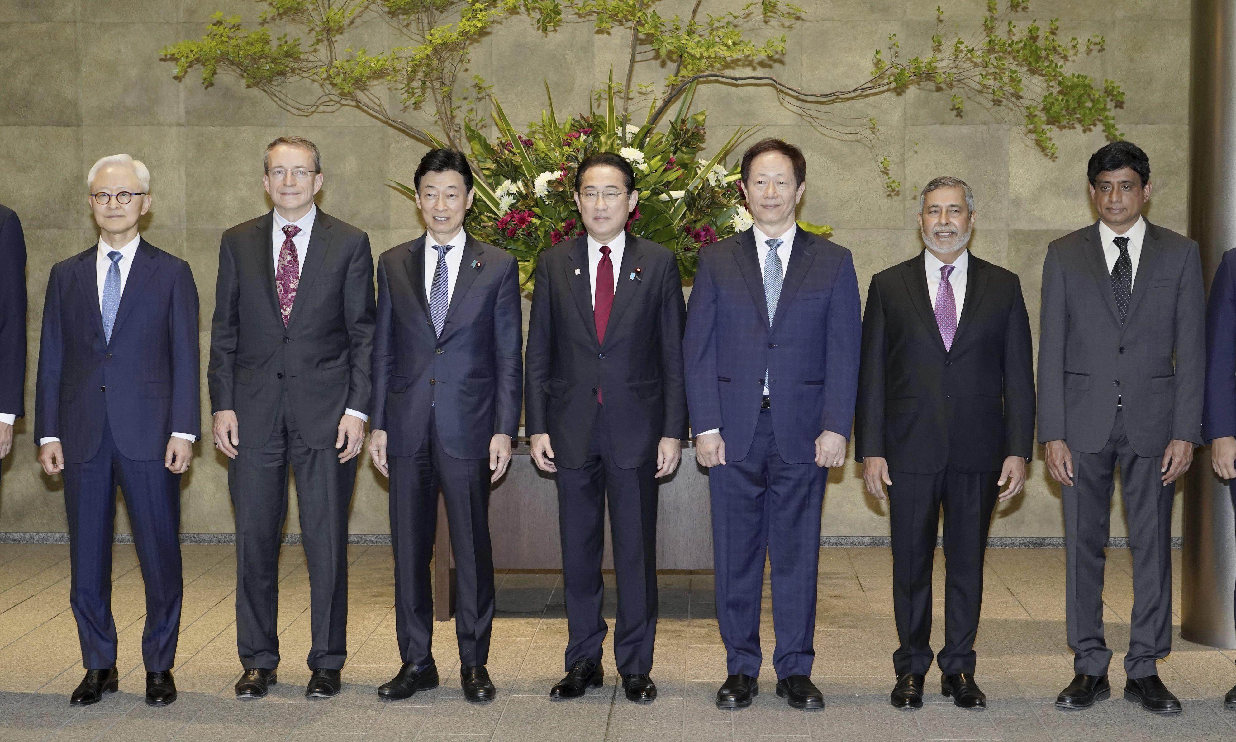 Japanese Prime Minister Fumio Kishida, centre, and Economy Minister Yasutoshi Nishimura, centre-right, pose with the heads of global chip companies. From left to right, Kyung Kye Hyun of Samsung, Patrick Gelsinger of Intel, Mark Liu of TSMC, Sanjay Mehrotra of Micron, and Prabu Raja of Applied Materials, on Thursday in Tokyo. Photo: Kyodo News via AP