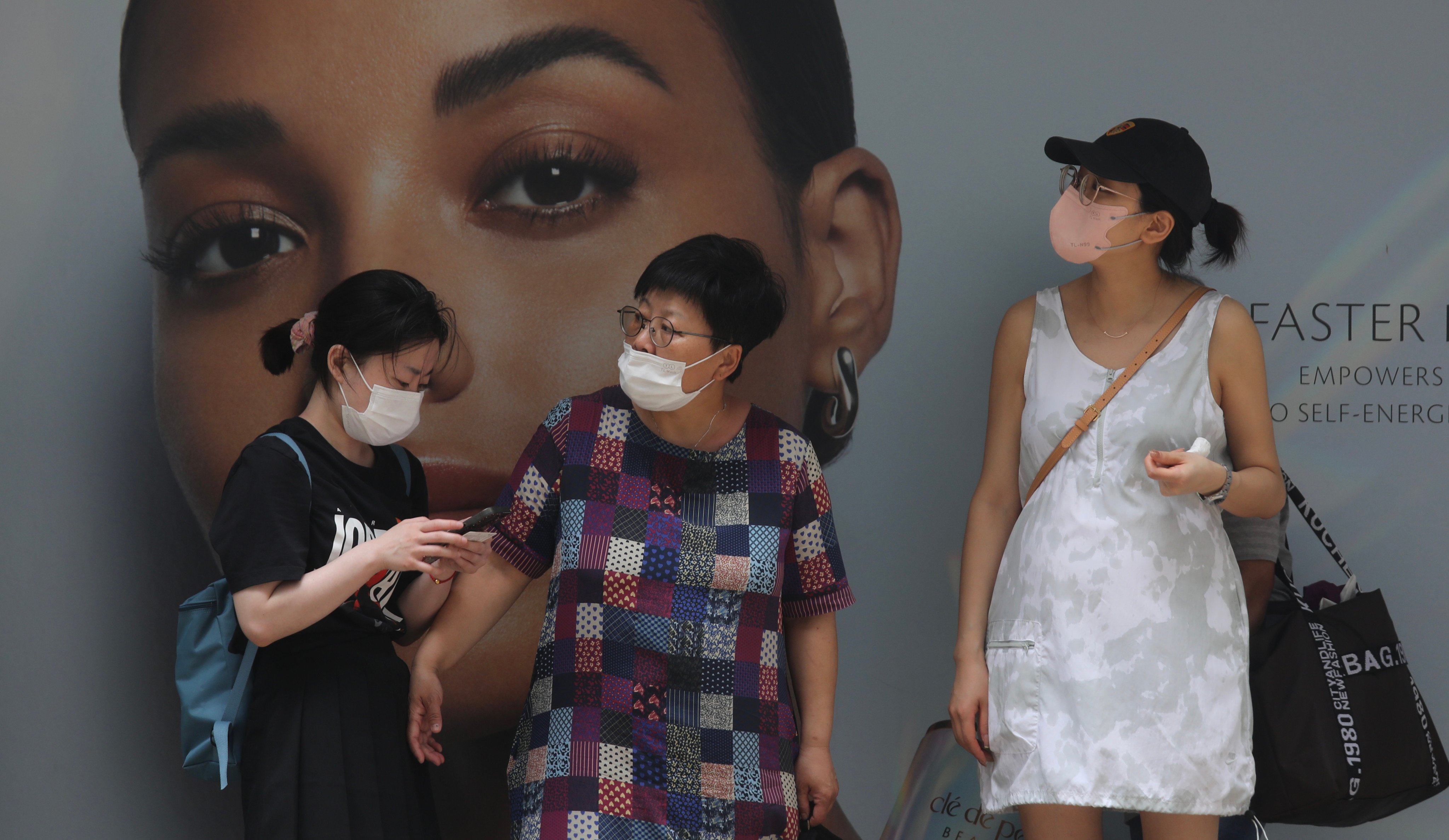 On the streets of Hong Kong, about half of people continue to wear the face coverings. Photo: Xiaomei Chen