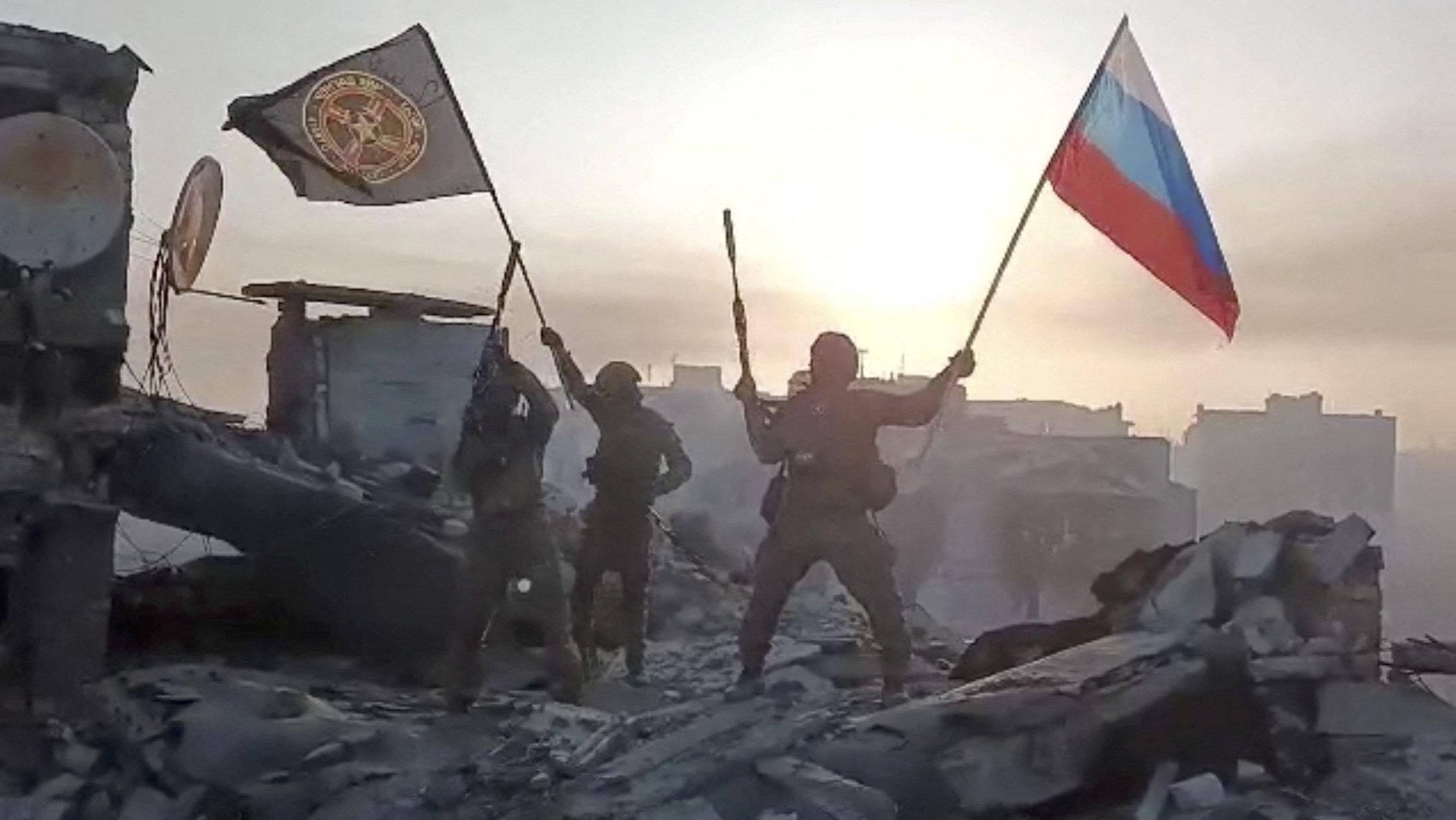 Members of Wagner group wave a Russian flag and Wagner Group’s flag on the rooftop of a damaged building in Bakhmut, Ukraine. Photo: Telegram channel of Concord group via AFP