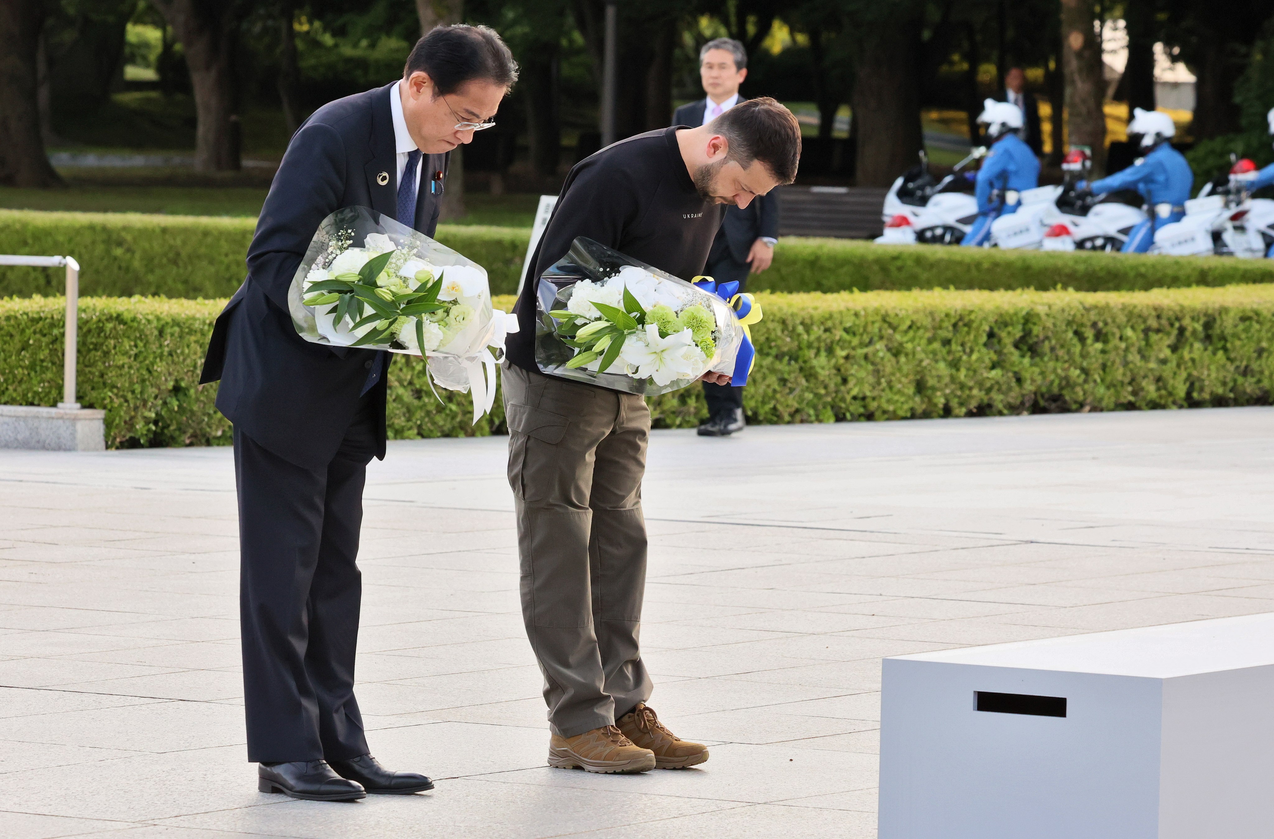 Japan’s Prime Minister Fumio Kishida, left, and Ukraine’s President Volodymyr Zelensky bow as they lay flowers in front of the Cenotaph for the Victims of the atomic nomb at the Hiroshima Peace Memorial Park in Hiroshima, Japan on Sunday. Photo: EPA-EFE / G7 Hiroshima Summit Host / Handout