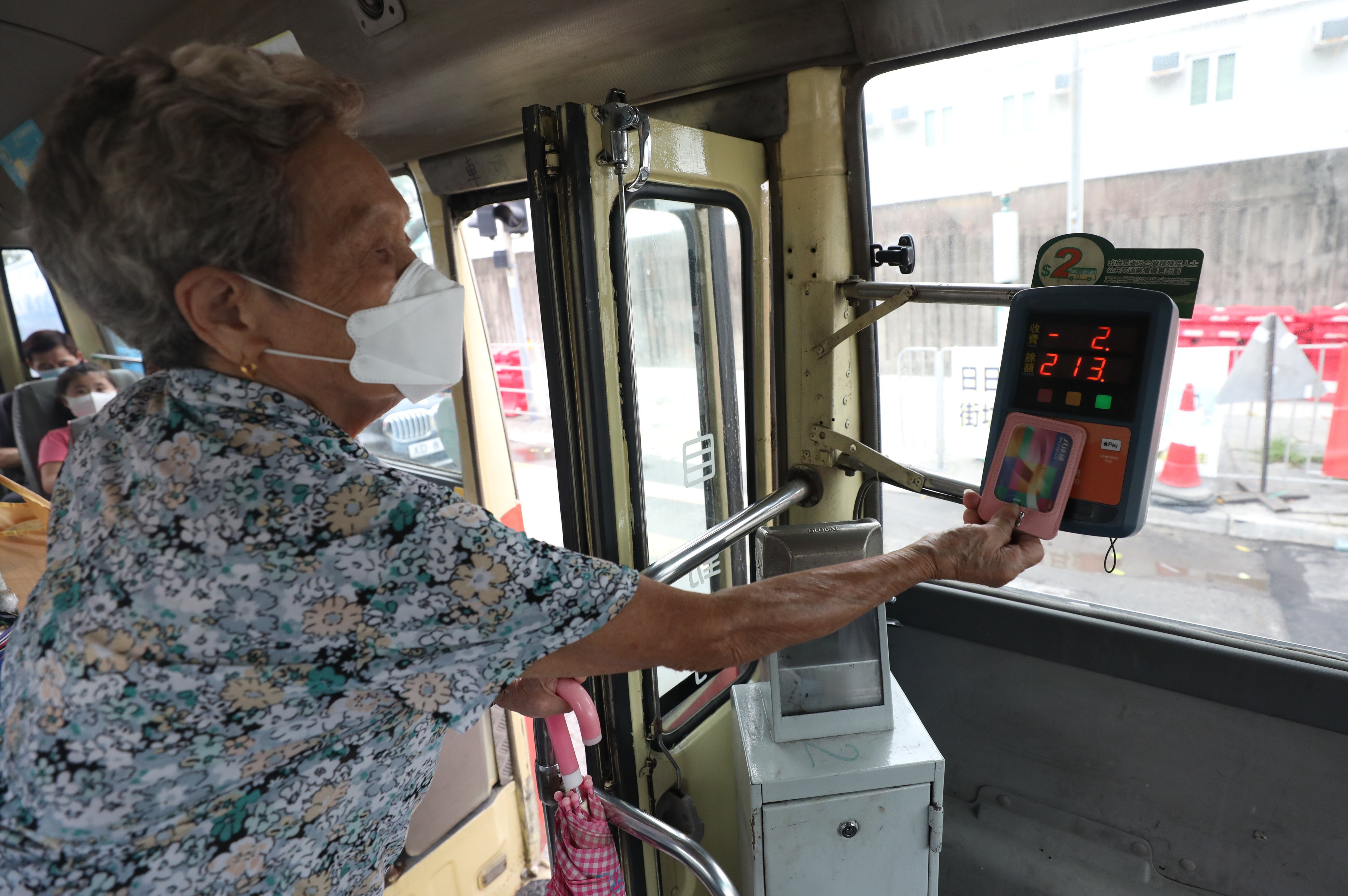 An elderly resident uses an Octopus card to pay a minibus fare. Photo: Xiaomei Chen