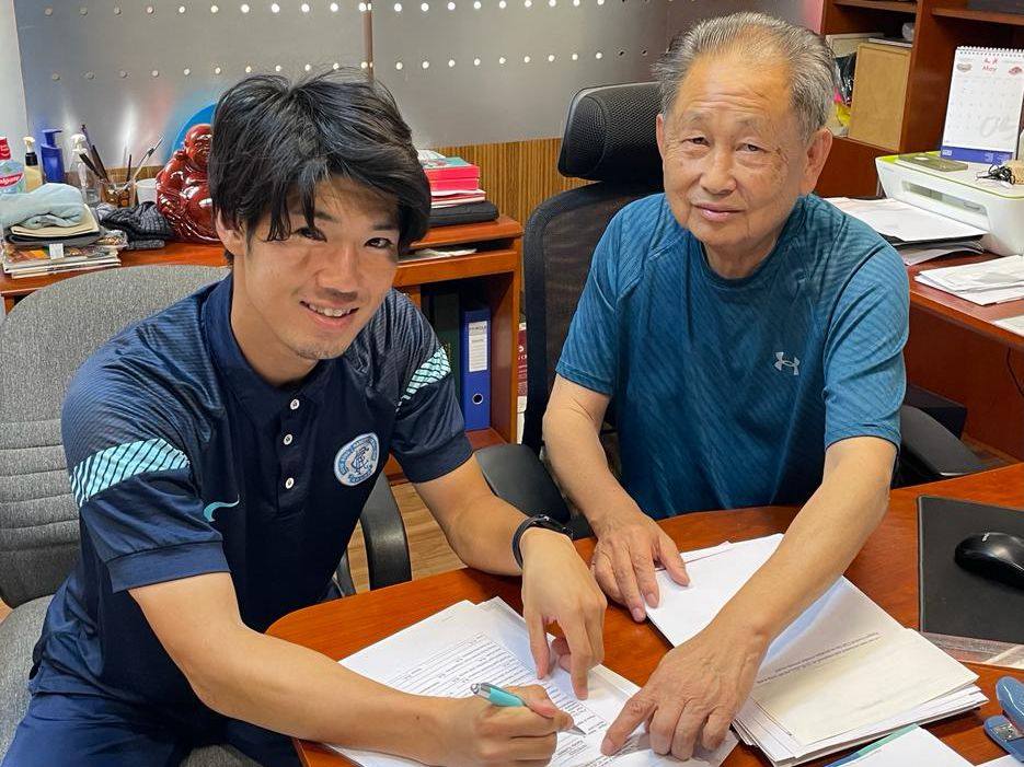 Yumemi Kanda signs a contract in front of Philip Lee to stay with BC Rangers for another season. Photo: BC Rangers