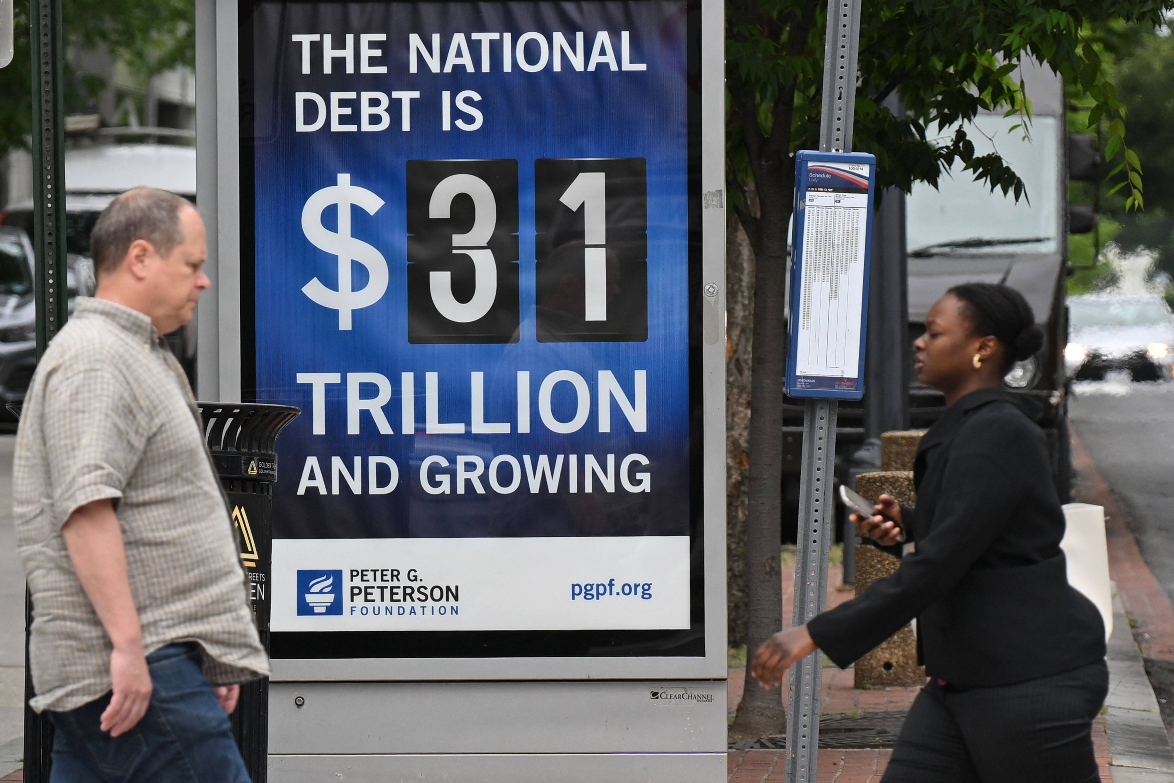 Pedestrians walk past a billboard showing the national debt in Washington on May 19. Photo: AFP