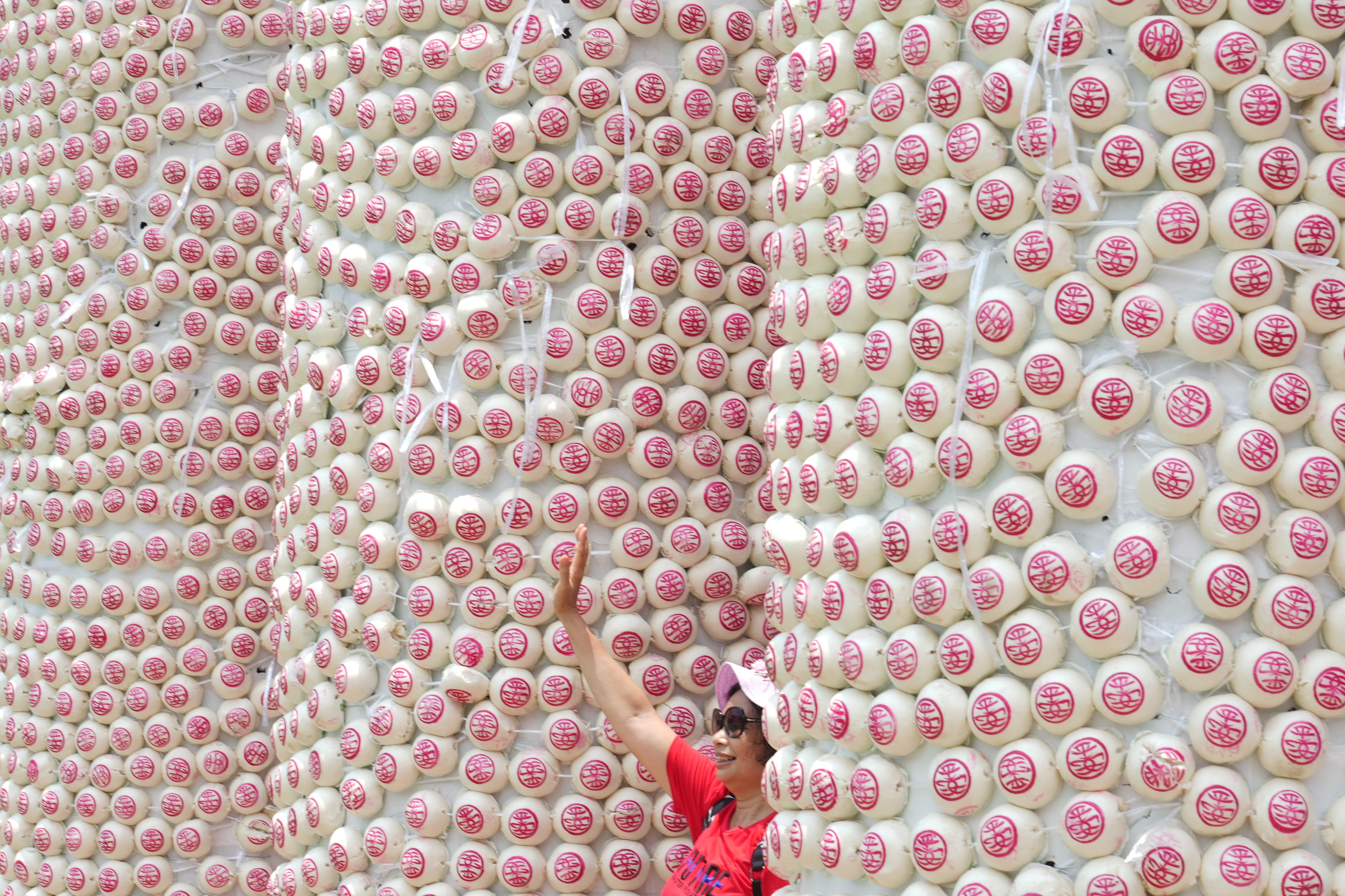 A visitor poses with the latest bun towers, which have been shortened because of manpower woes. Photo: Sam Tsang