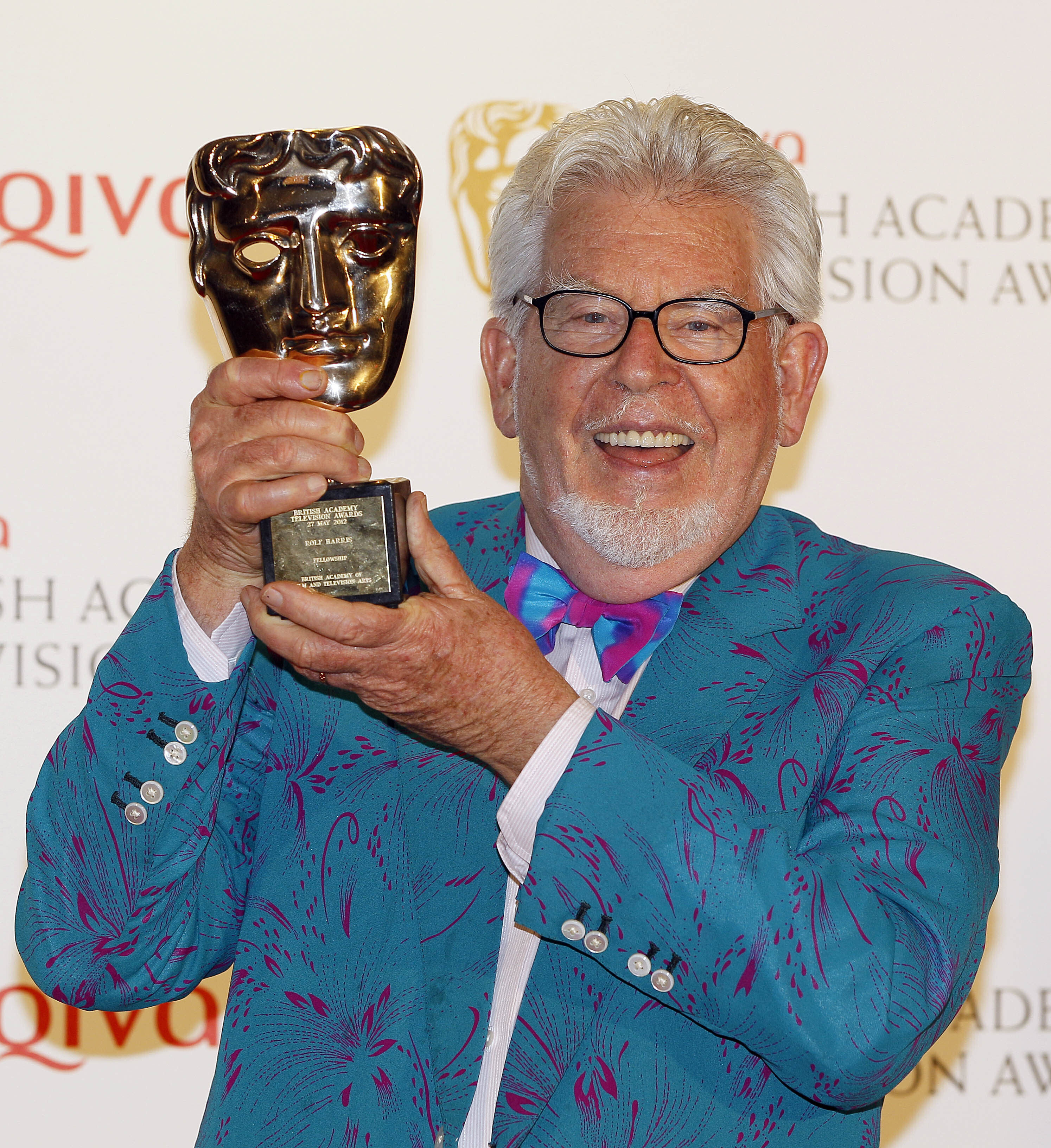 Australian entertainer Rolf Harris holds up a TV award in London in 2012. In 2014 he was convicted of abusing young girls decades before, and sent to prison. Photo: AP