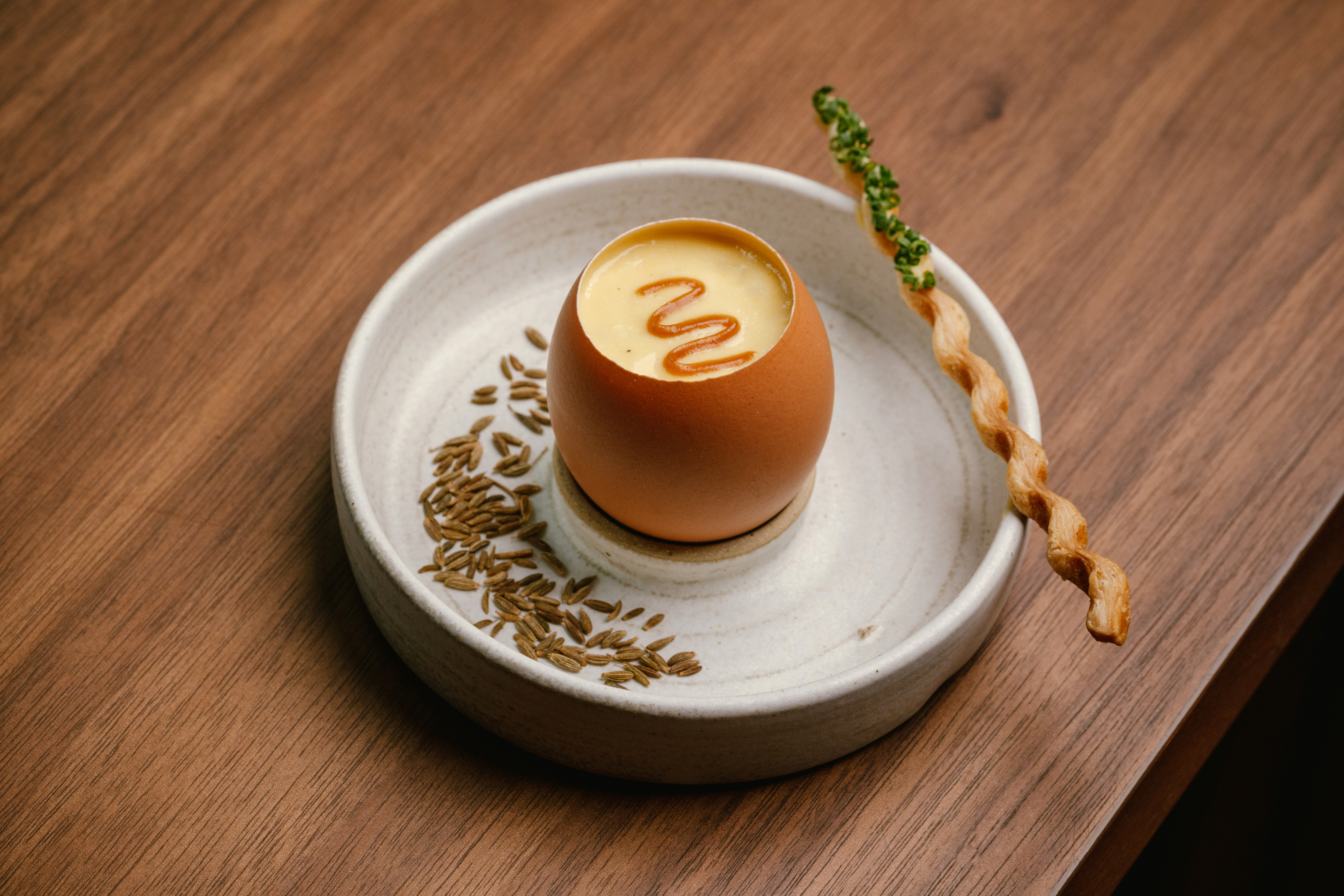 Among the starters at Feuille is creamed egg and corn embossed with a squiggle of cumin caramel and served in the shell with matchstick-thin breadsticks for dipping.jpg at Feuille, 2023.   &#xA;&#xA;&#xA;Credit: Feuille