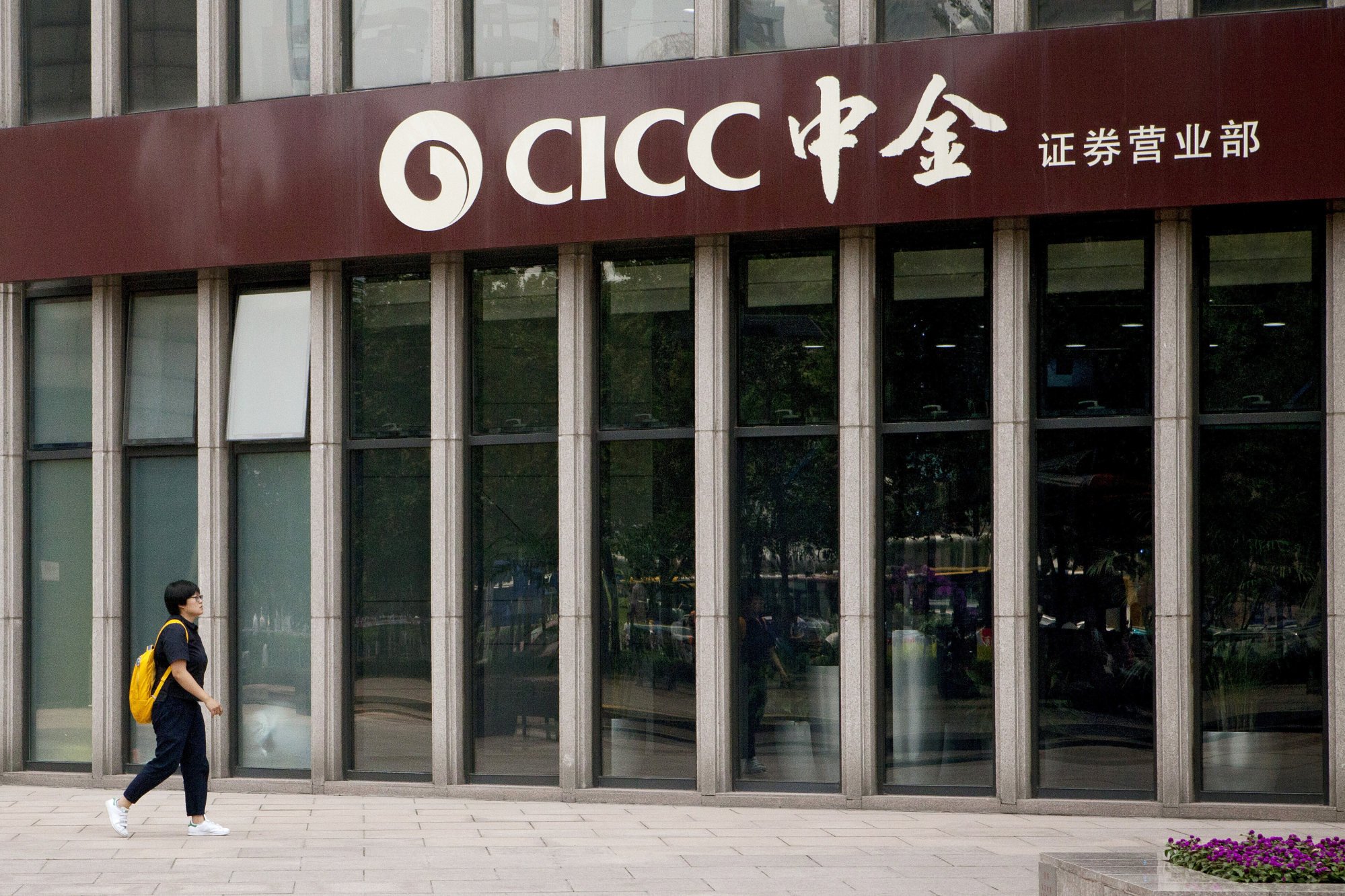 A pedestrian passes a China International Capital Corp. (CICC) securities brokerage branch in Beijing in 2016. Photo: Bloomberg