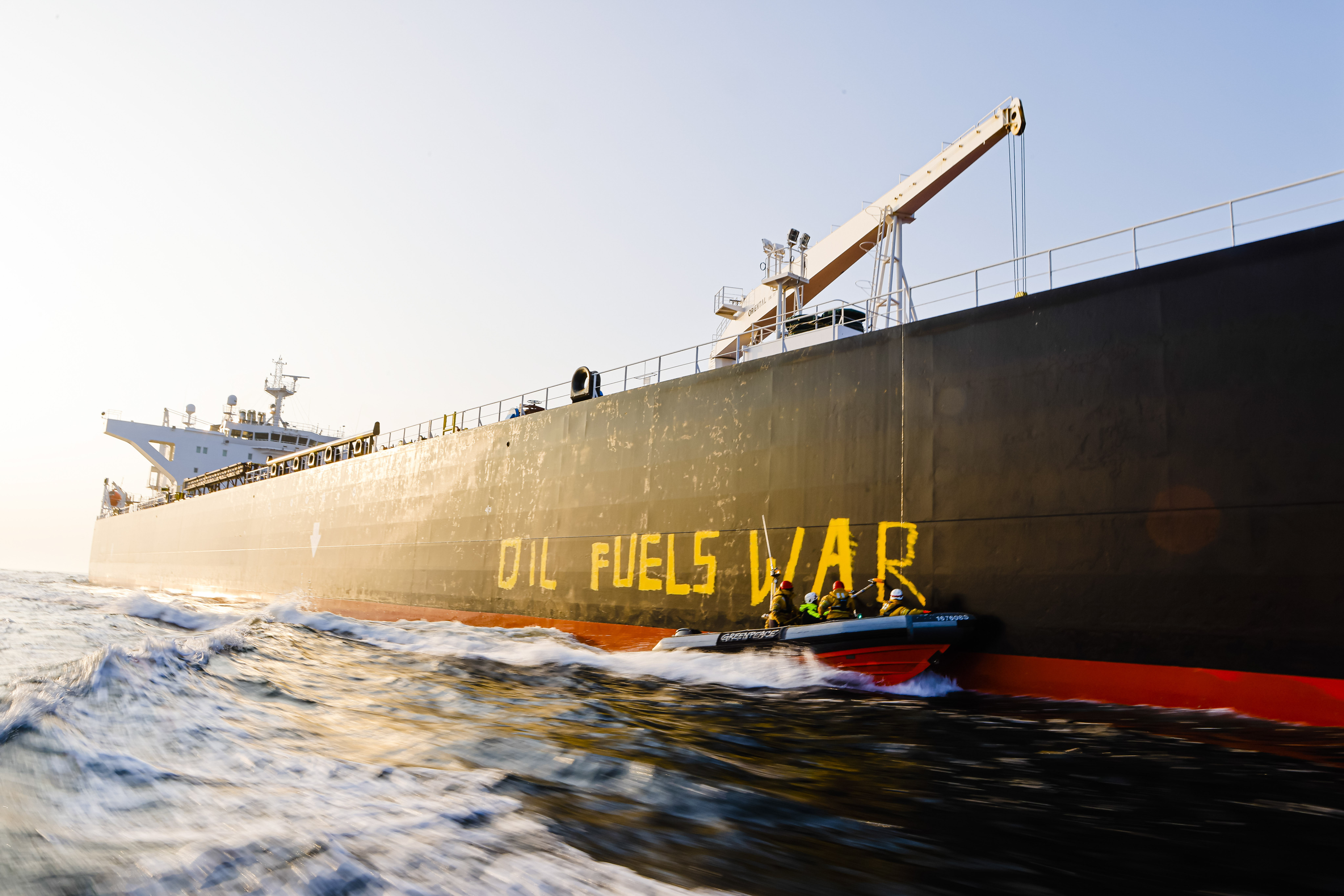 Activists from the environmental organisation Greenpeace paint the words “Oil fuels war” on the hull of a ship carrying Russian oil on the Baltic Sea. Photo: dpa