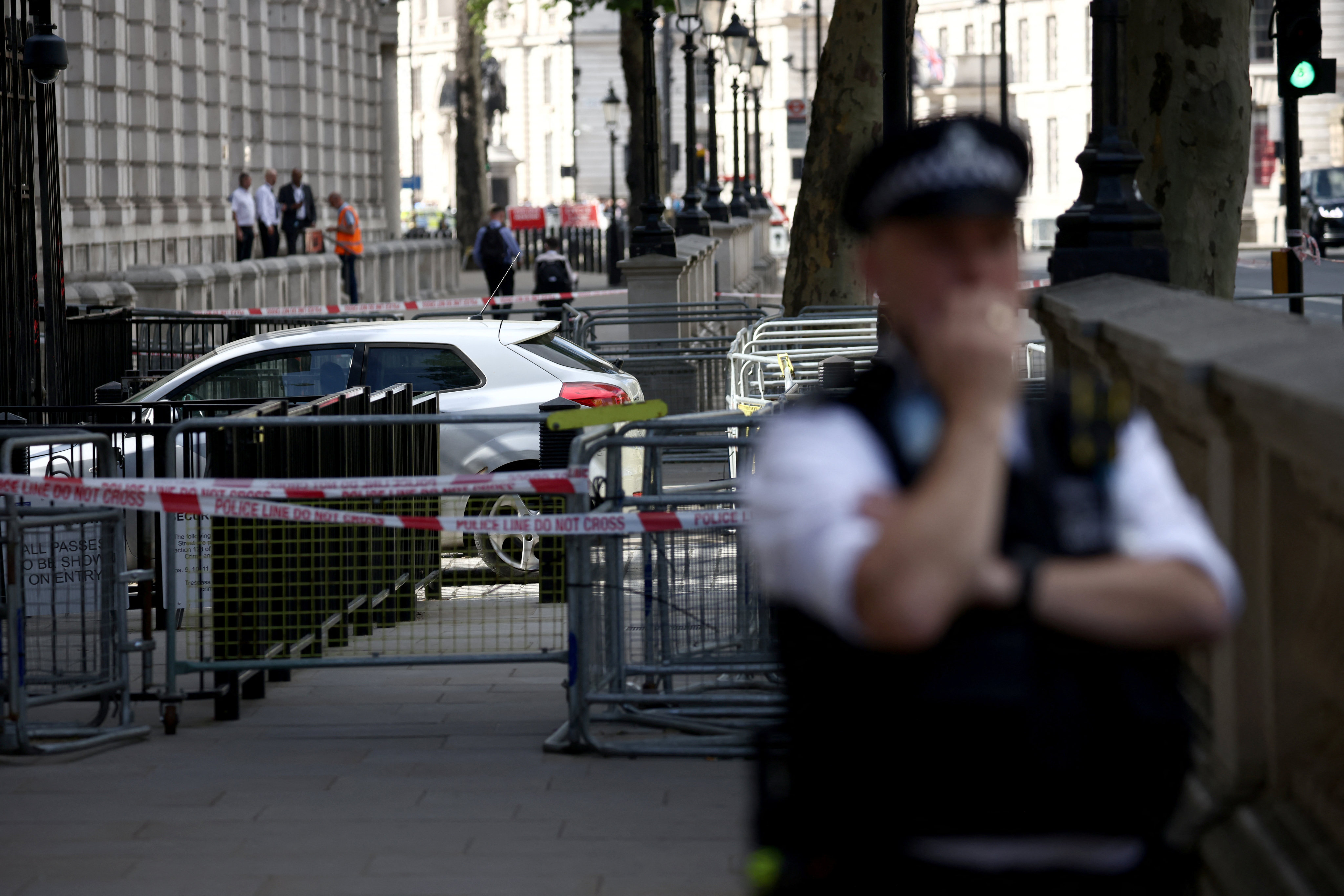 A police officer stands guard near the site where a car crashed into the front gates of Downing Street in London on Thursday. Photo: Reuters