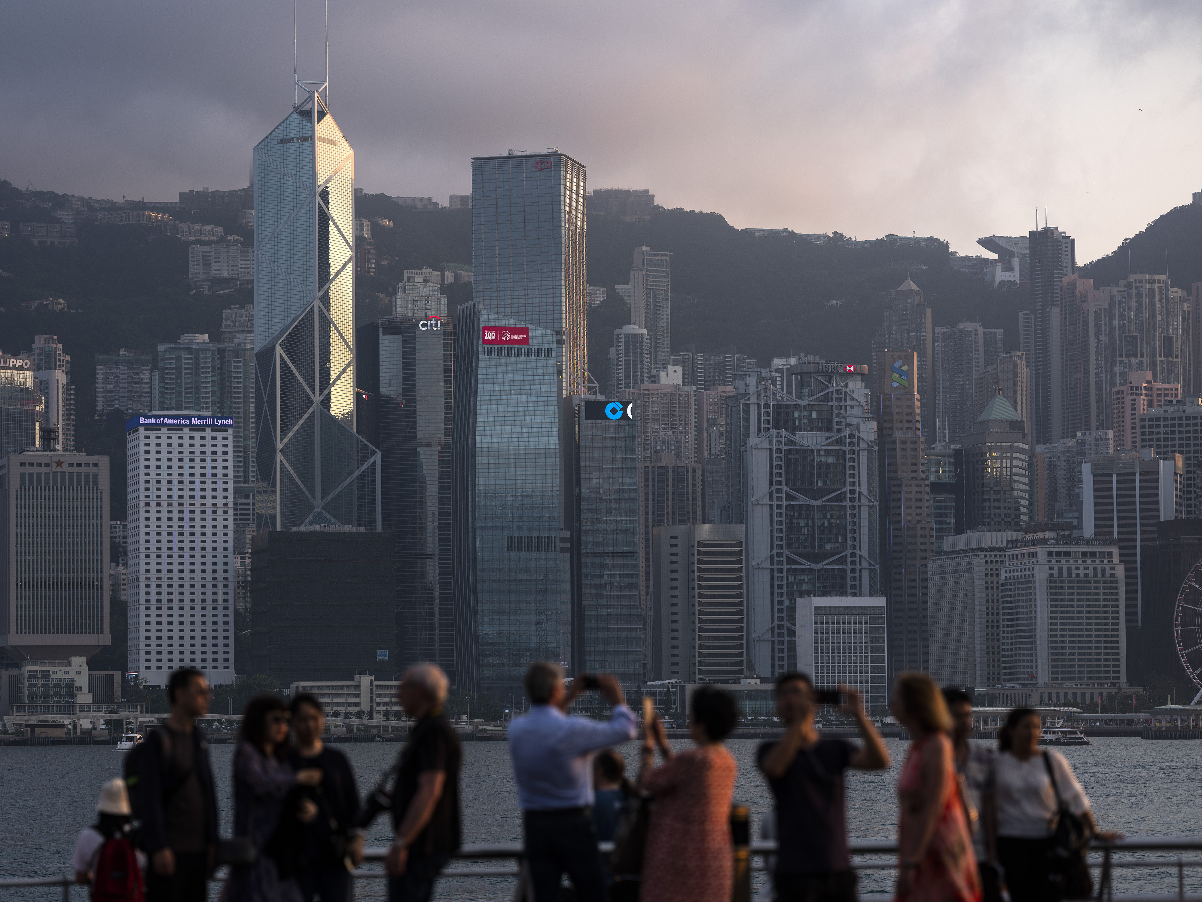 People take photos of the Hong Kong skyline featuring major banks from the Tsim Sha Tsui waterfront on April 29, 2019. Photo: Bloomberg