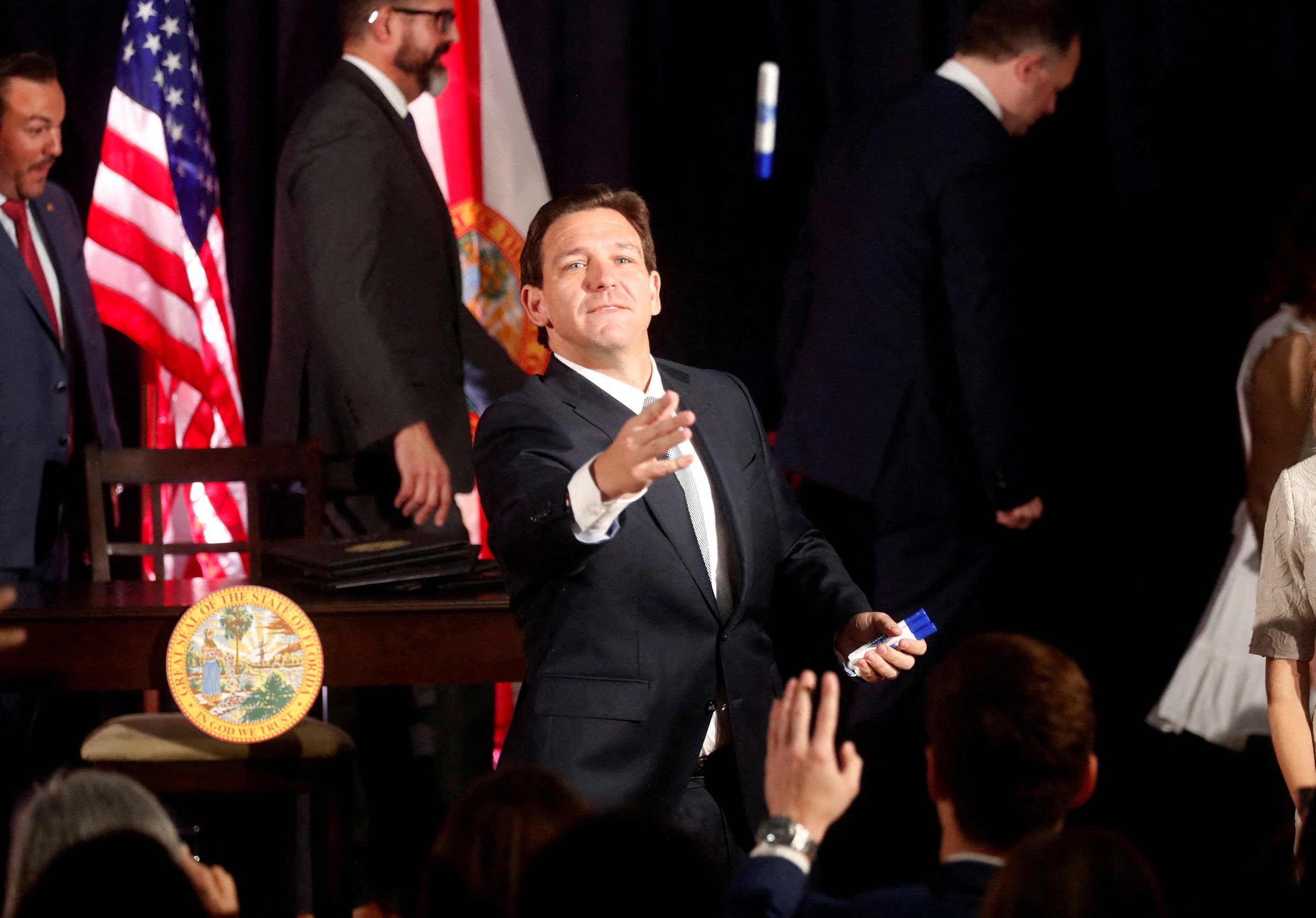 Florida Governor Ron DeSantis tosses a pen to students while signing five state bills into law after giving a press conference at Cambridge Christian School in Tampa, Florida, on May 17. Photo: Reuters