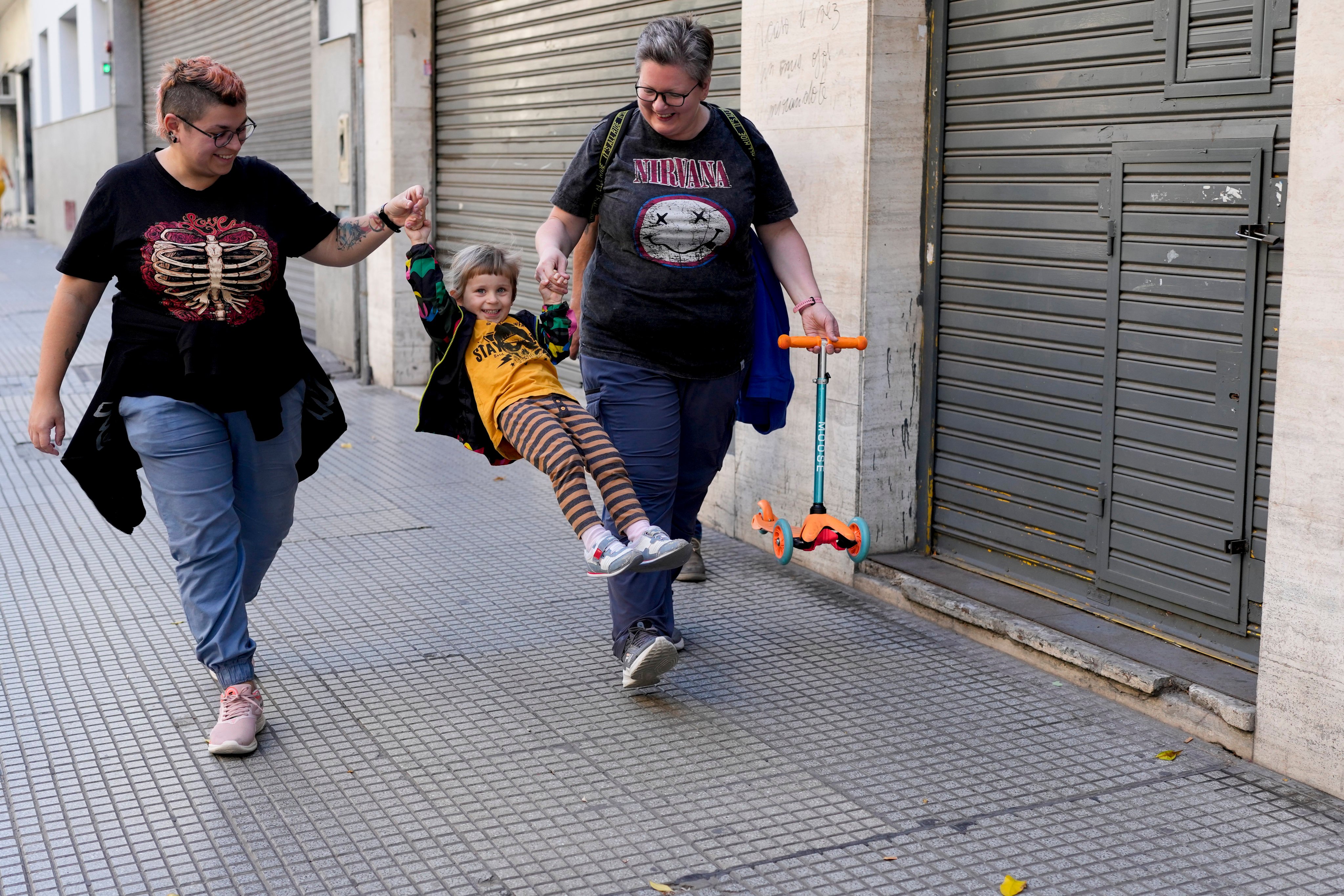 Anastasia Domini, left, and her wife Anna swing their daughter Una as they walk to a park in Buenos Aires. The couple are among many Russians who have left their homeland to escape discrimination and settled in Argentina, where same-sex marriage is legal. Photo: AP