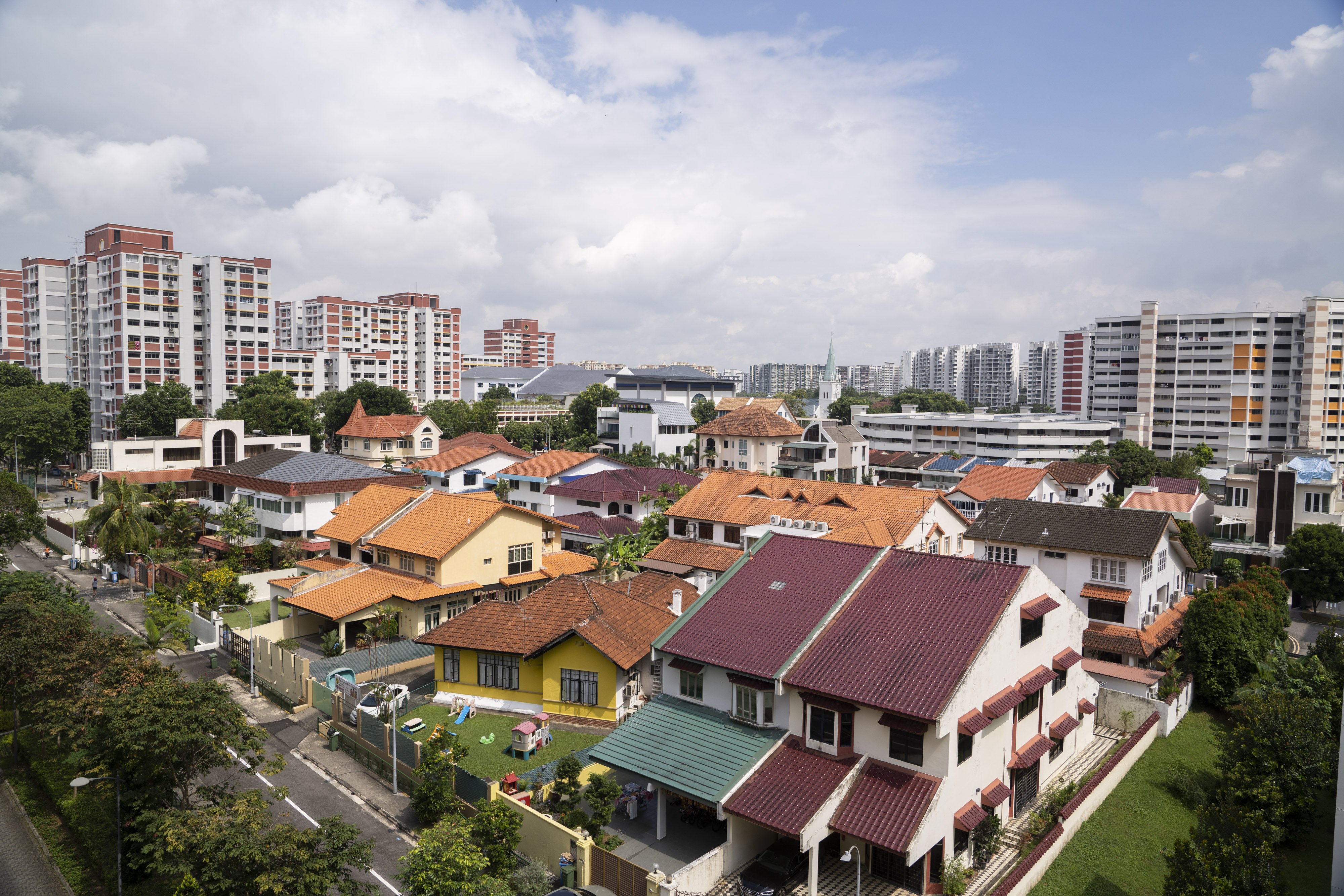 Private residential houses are seen in front of Housing & Development Board (HDB) public housing estates in the Hougang area of Singapore. Photo: Bloomberg