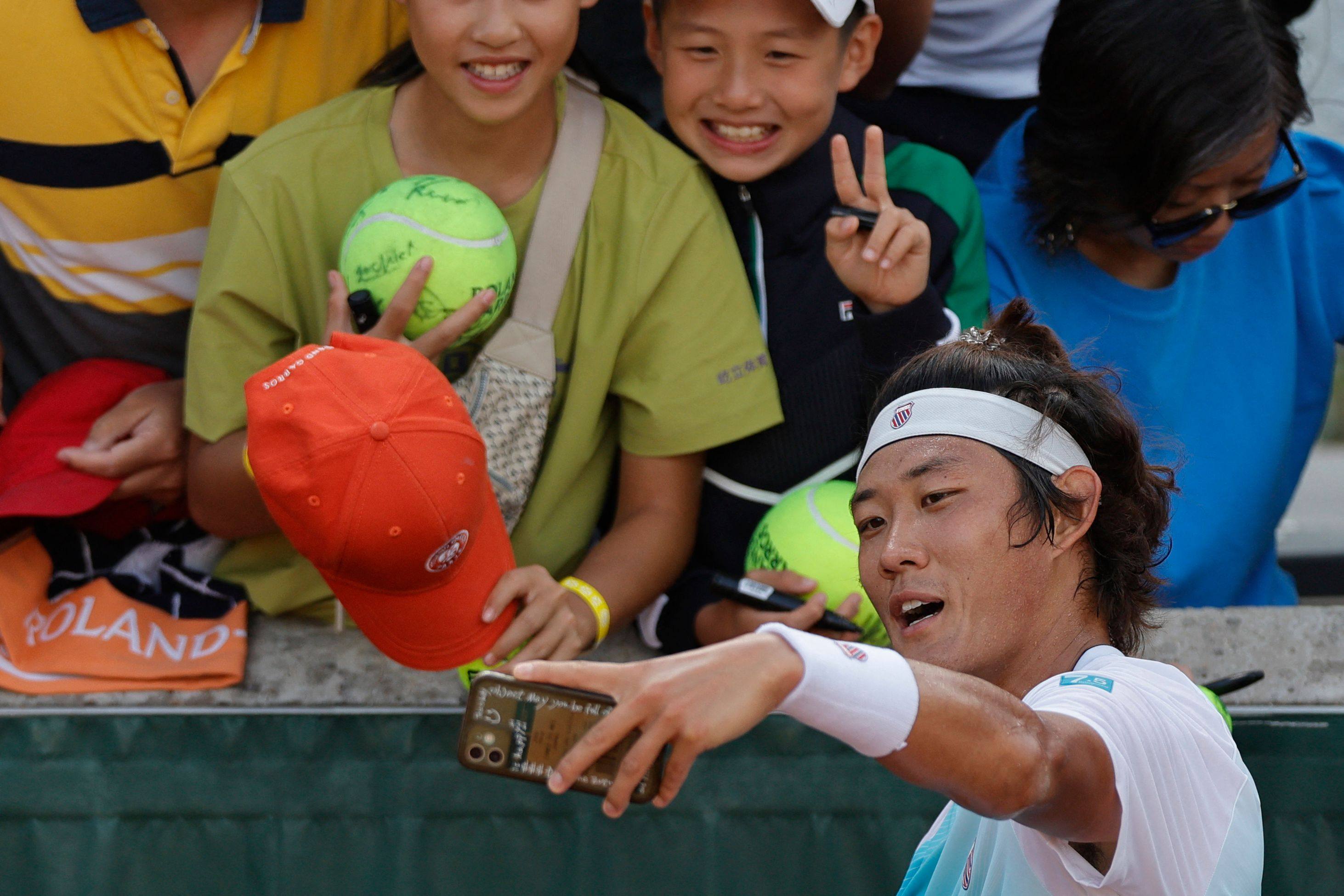 China’s Zhang Zhizhen poses for aselfie with fans after his victory over Serbia’s Dusan Lajovic. Photo: AFP