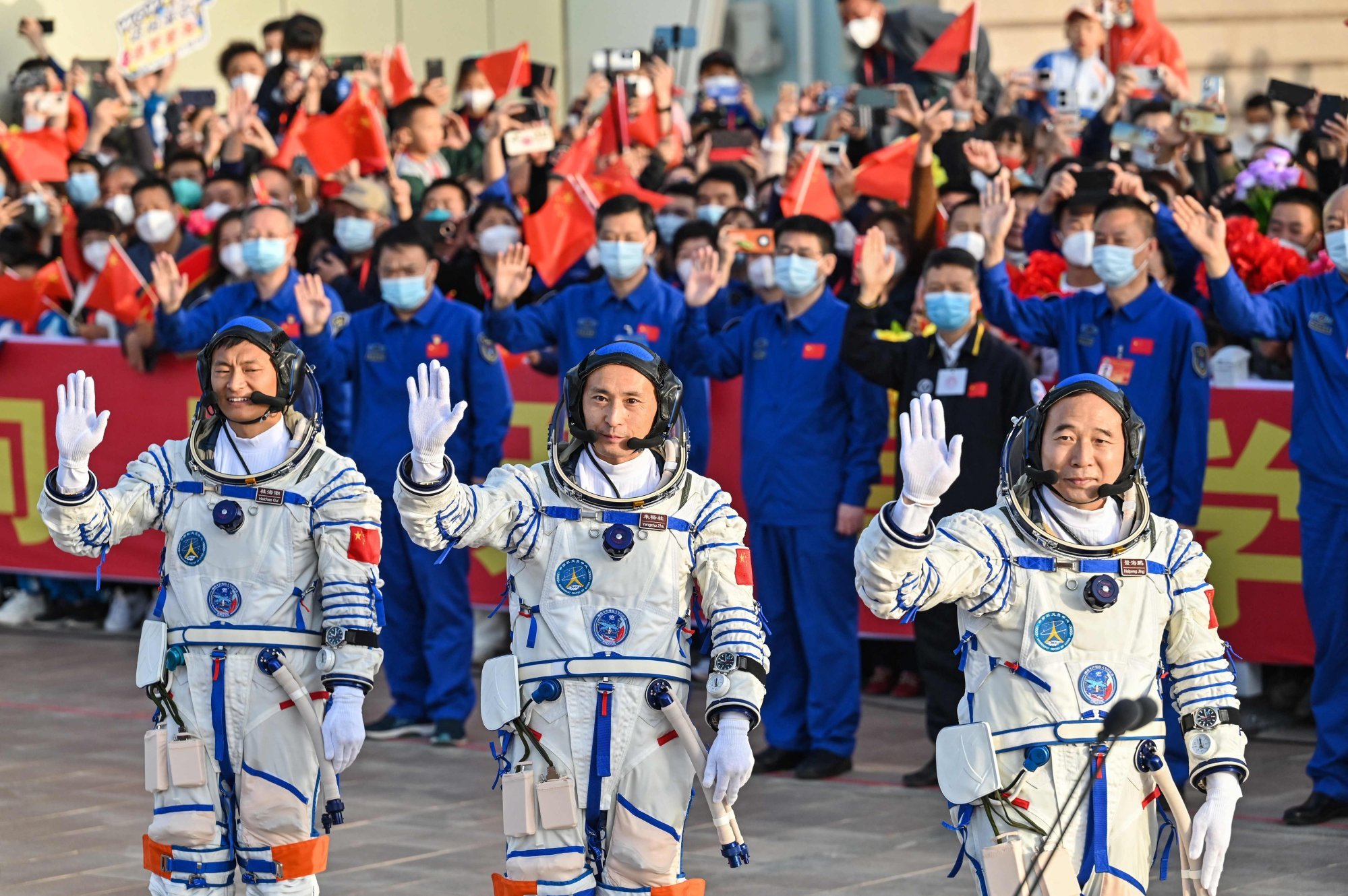 Chinese astronauts, from left, Gui Haichao, Zhu Yangzhu and commander Jing Haipeng wave goodbye before boarding the Shenzhou-16 manned space flight mission at the Jiuquan Launch Centre in the Gobi desert on Tuesday. Photo: AFP