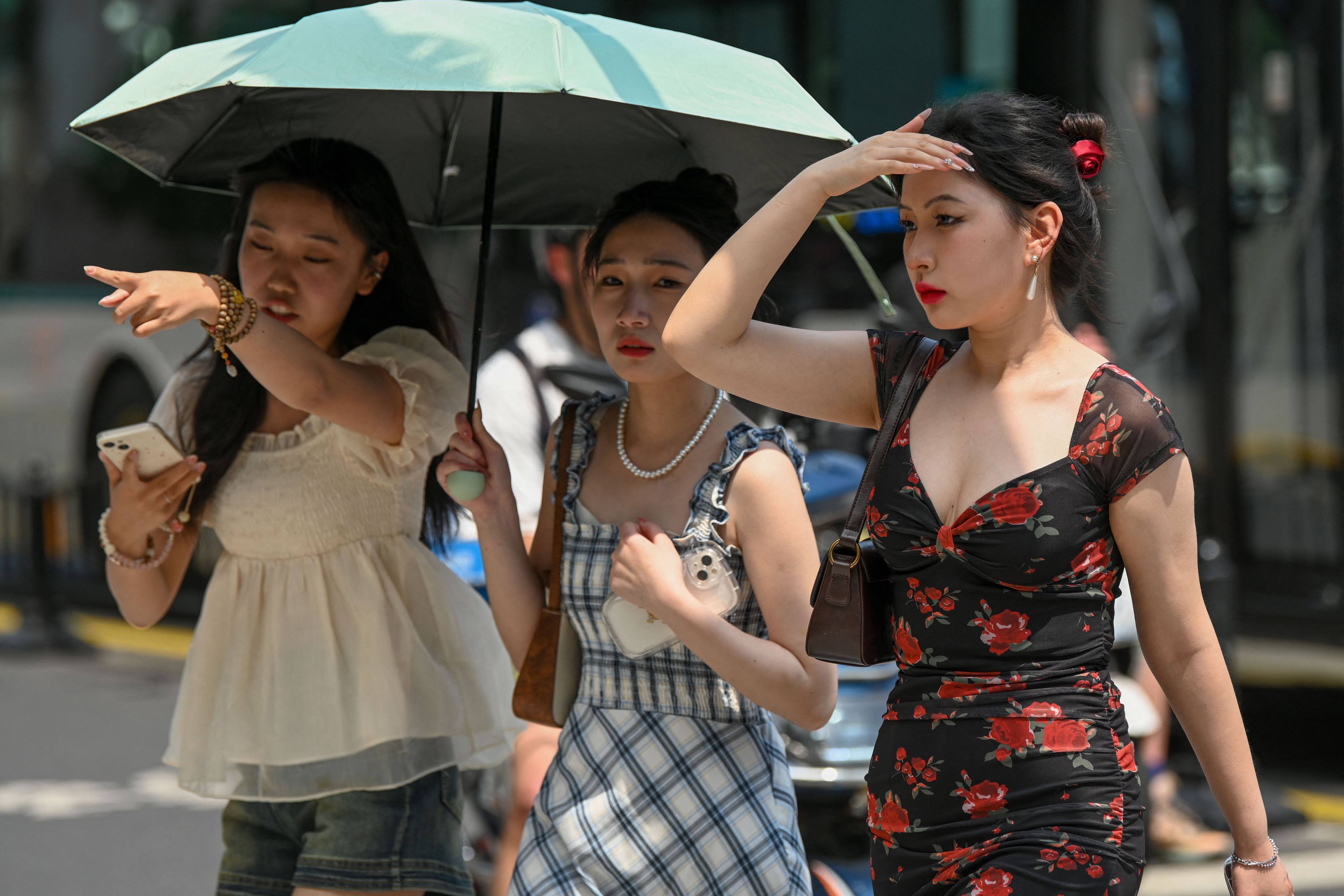 Women use an umbrella to shelter from the sun amid hot weather in Shanghai. Shanghai on May 29 recorded its hottest May in 100 years, shattering the previous high by a full degree. Photo: AFP