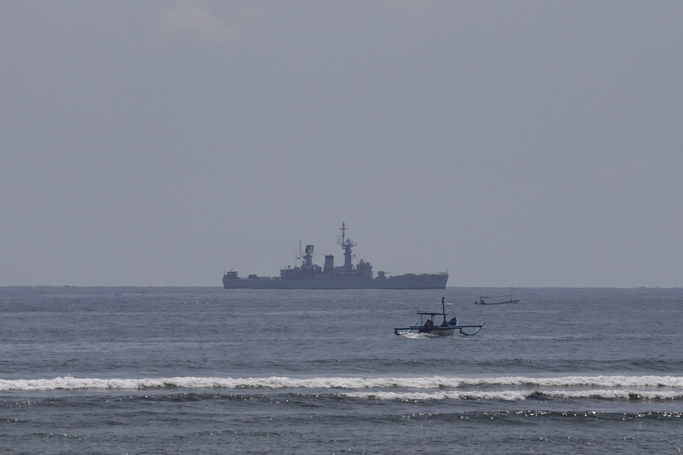 Fishing boats sail past as an Indonesian Navy ship patrols in the water off Nusa Dua, Bali. Indonesia’s drills come as China and the United States ramp up military diplomacy in the region. Photo: EPA-EFE