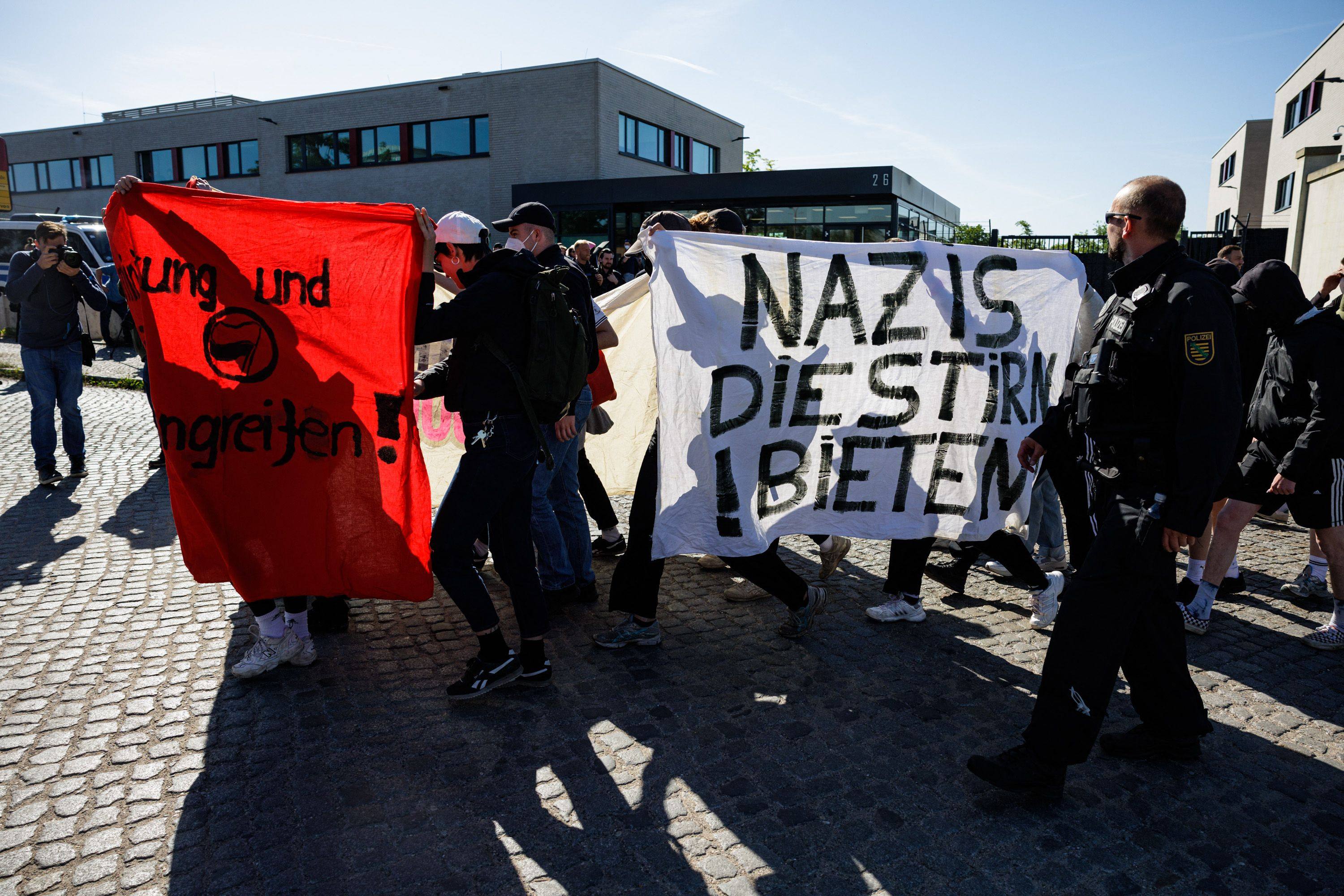 Demonstrators hold a banner as they run along of the front of the courthouse of the higher regional court in Dresden ahead the trial against left-wing extremist Lina E. Photo: AFP