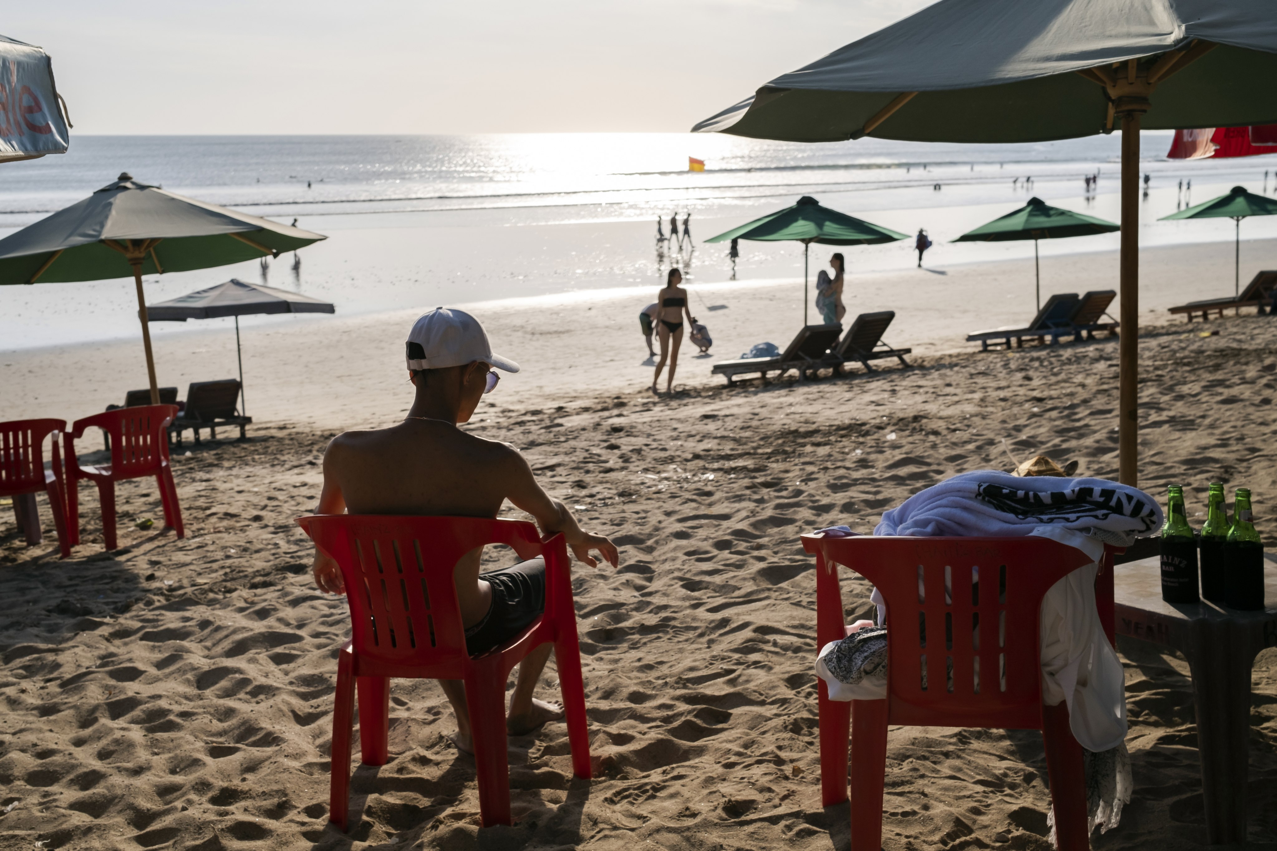 Foreign tourists sit at a beach in Kuta, Bali last month. Photo: EPA-EFE