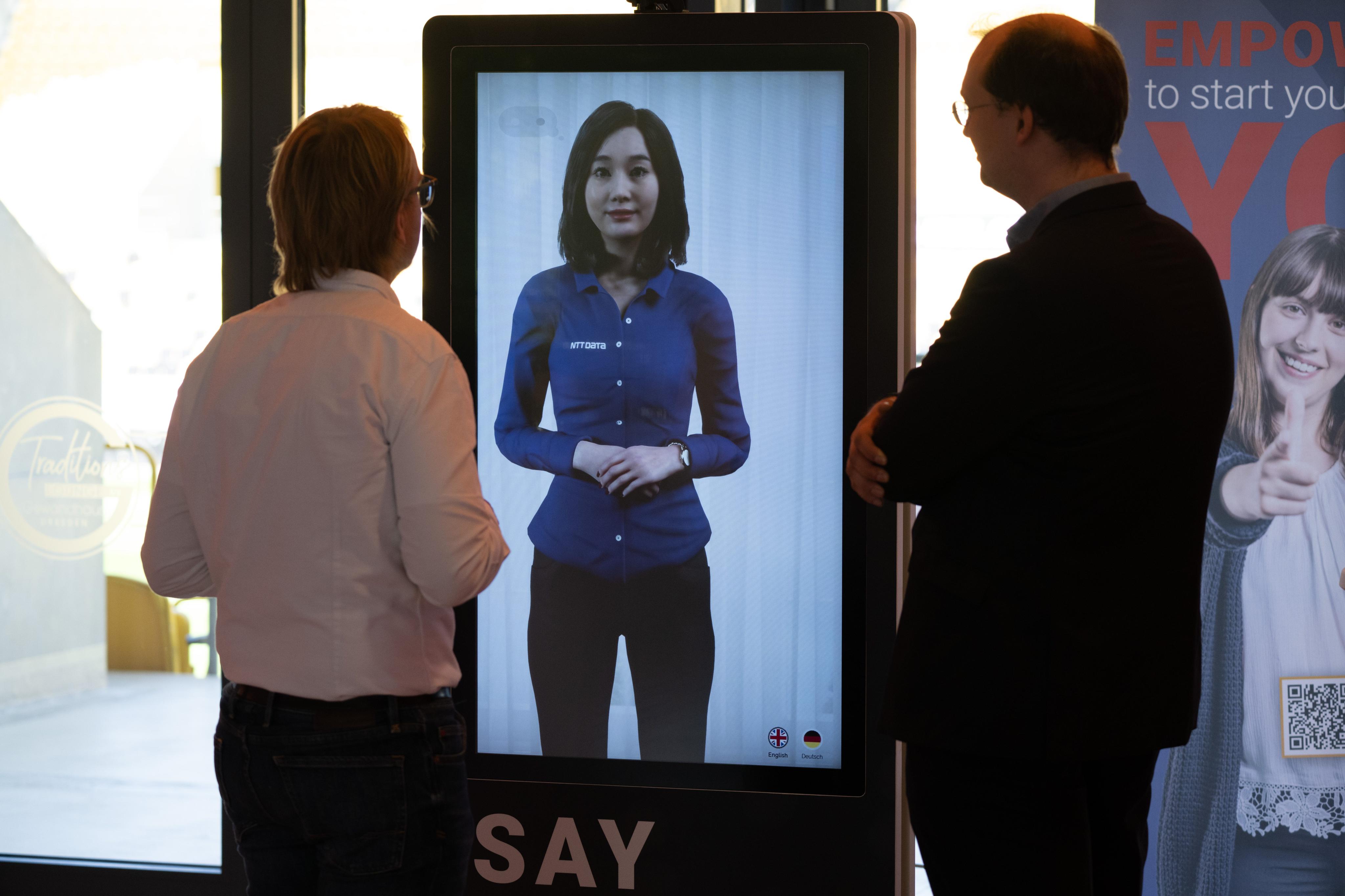 Participants of the Saxony state government’s congress in Dresden, Germany, on artificial intelligence on May 25 stand in front of an AI avatar that combines human interactions with current knowledge. Photo: DPA