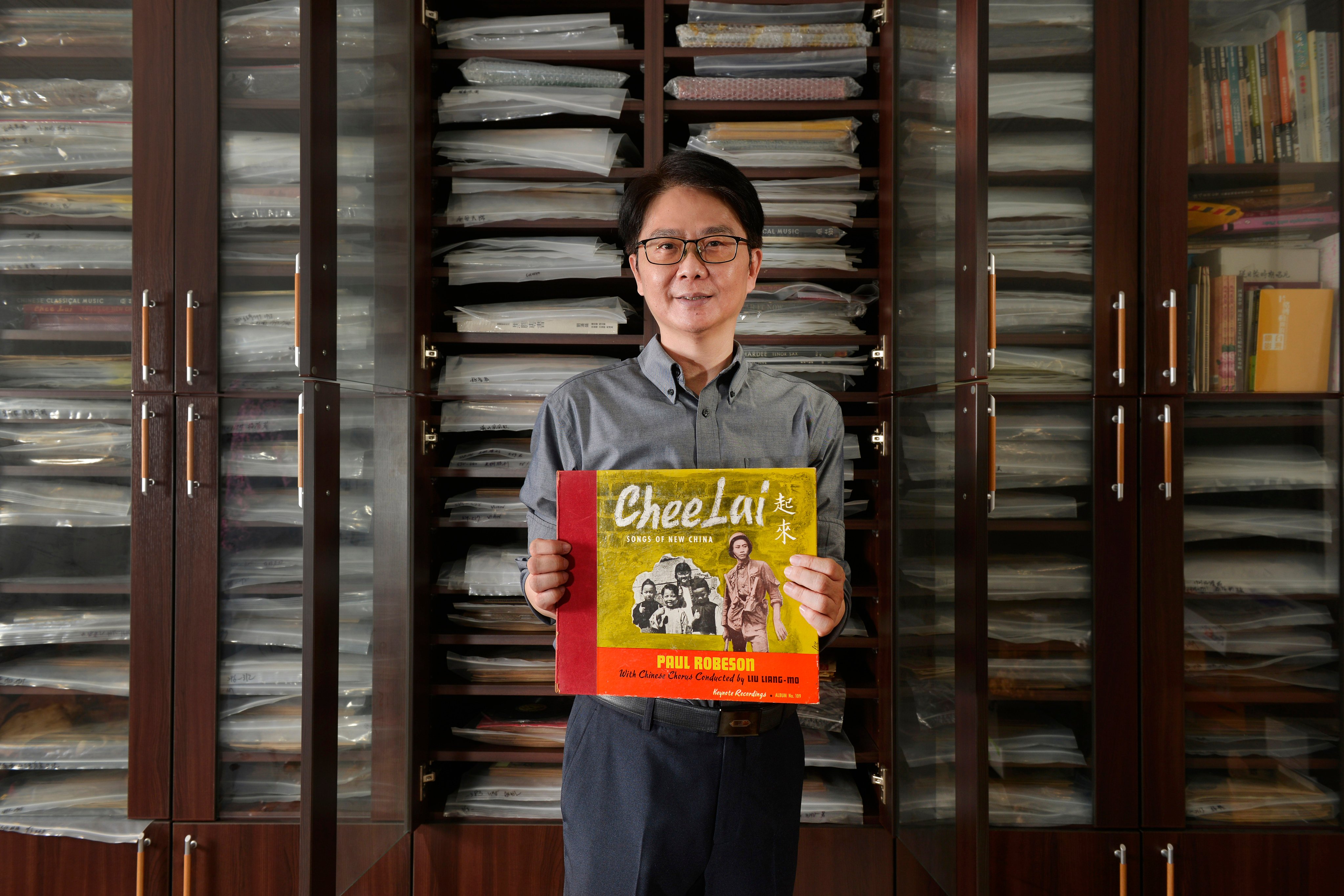 Hsu Deng-fang holds one of his rare records, with a small part of his collection stacked behind him. Photo: Chris Stowers/Panos