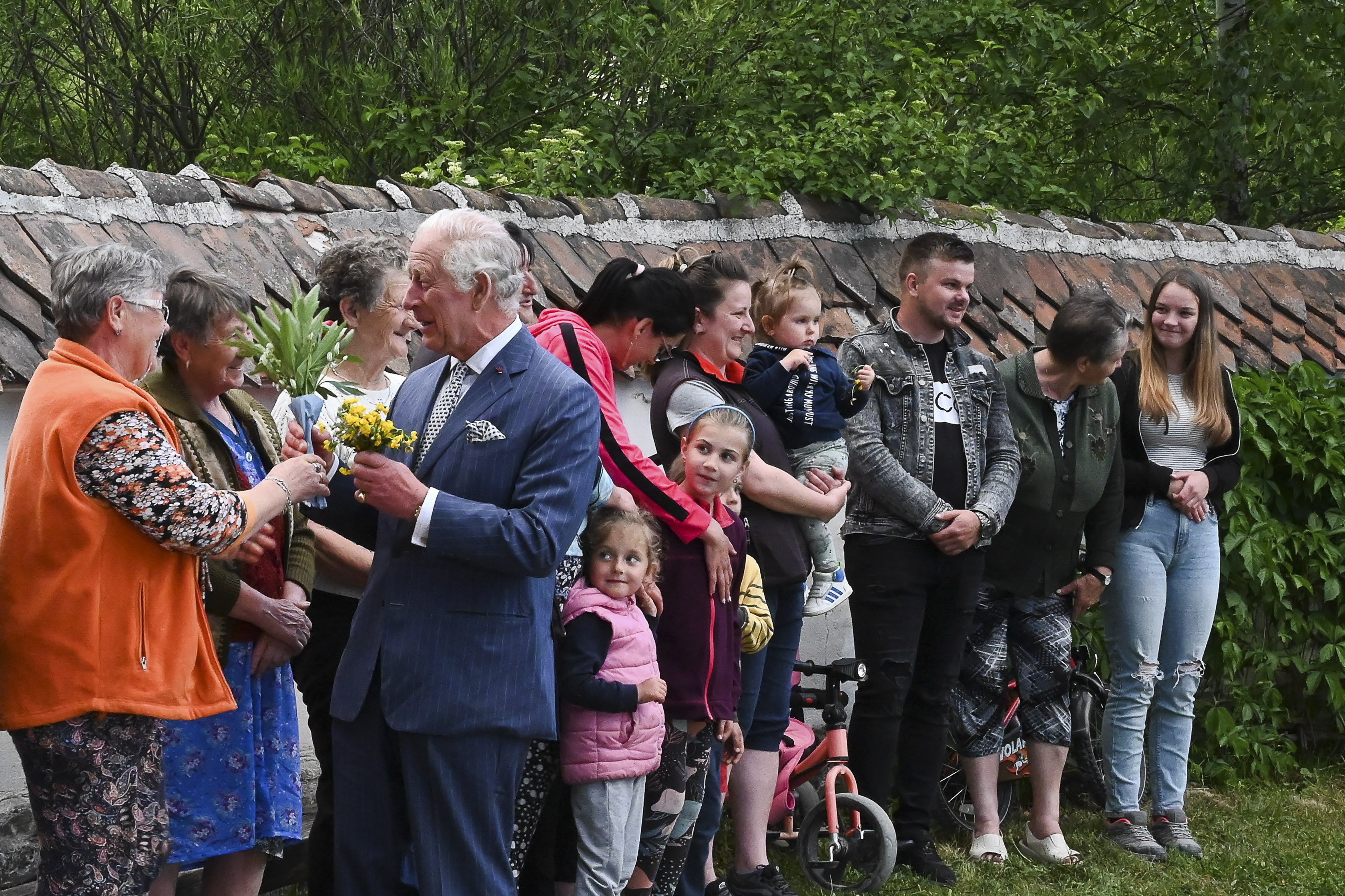 Britain’s King Charles receives flowers from locals as he arrives at his estate in Valea Zalanului (Zalan Valley), eastern Transylvania, Romania on Friday. Photo: EPA-EFE
