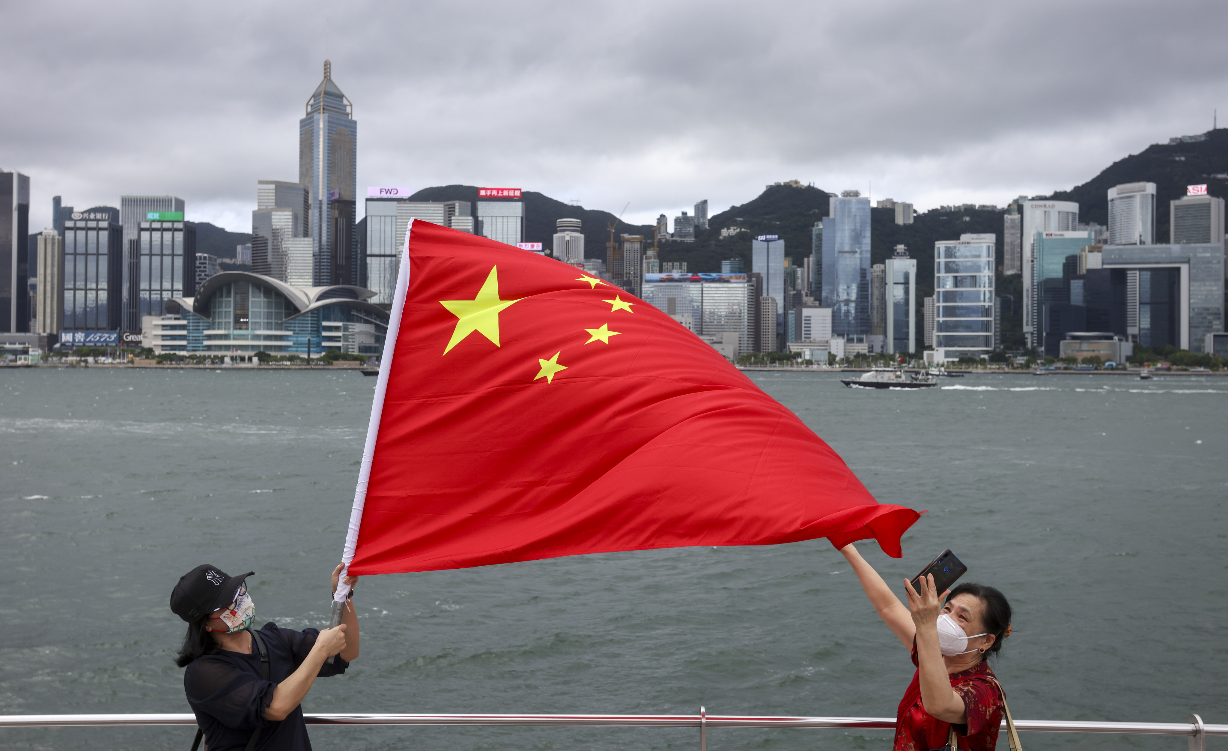 Residents celebrate the 25th anniversary of Hong Kong’s return to Chinese rule last year by waving the national flag at the Tsim Sha Tsui waterfront. Photo: Nora Tam