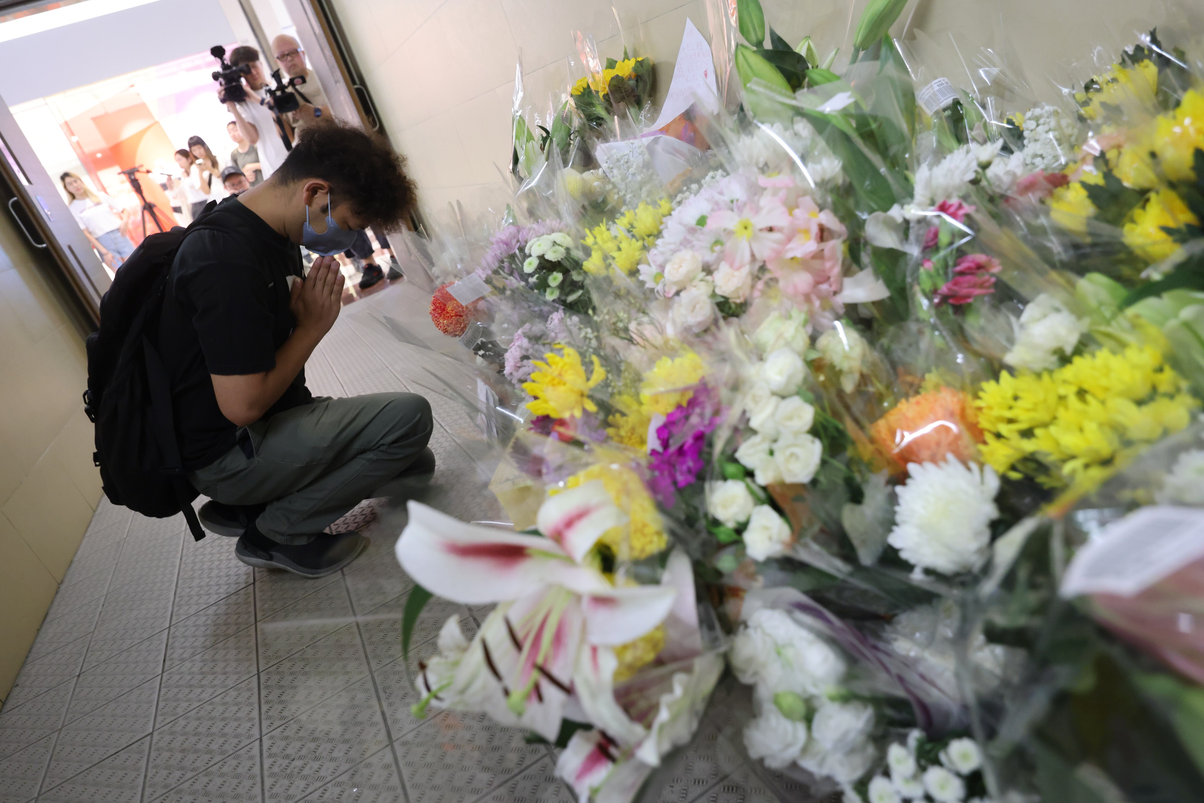 People leave flowers in tribute to the two women killed at Plaza Hollywood on Friday. Photo: Mary Tse