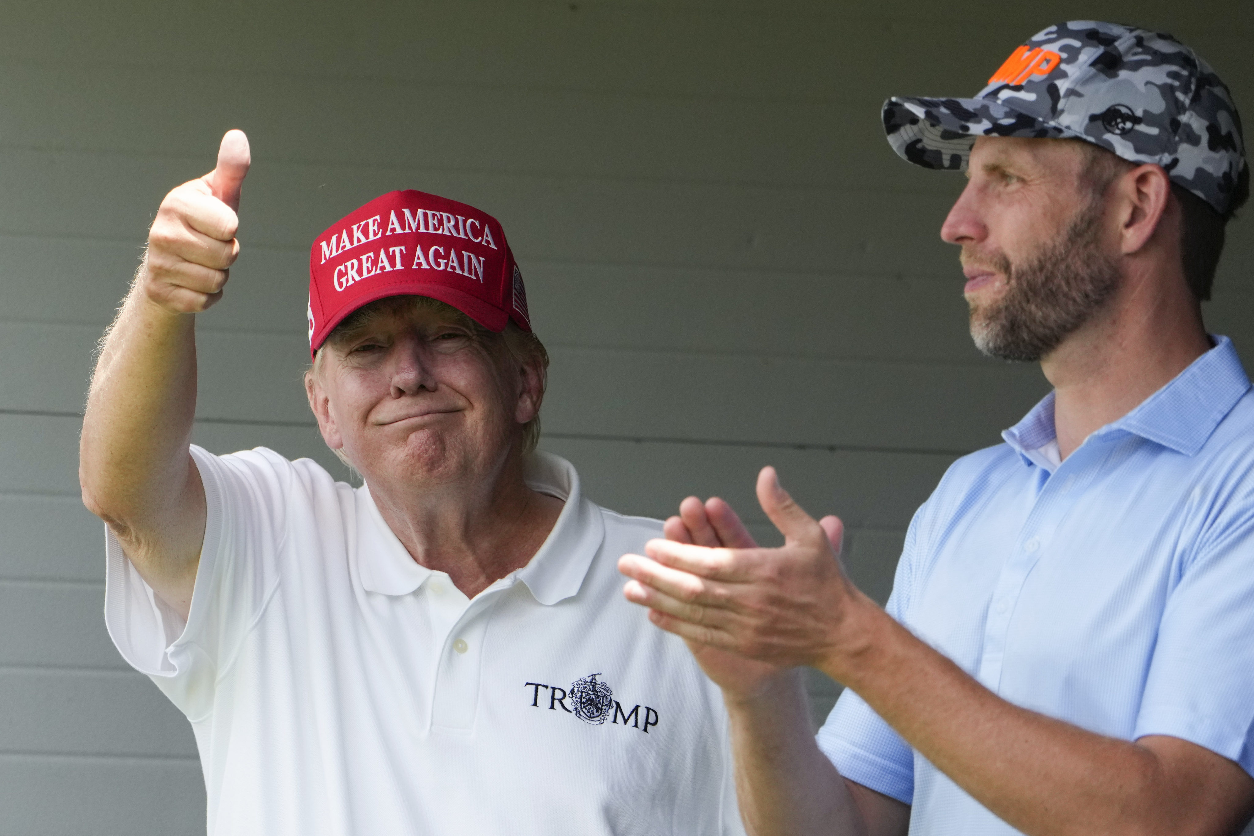 Donald Trump gives a thumbs up as he watches golf with his son Eric at his golf club in the US state of Virginia last month. Photo: AP