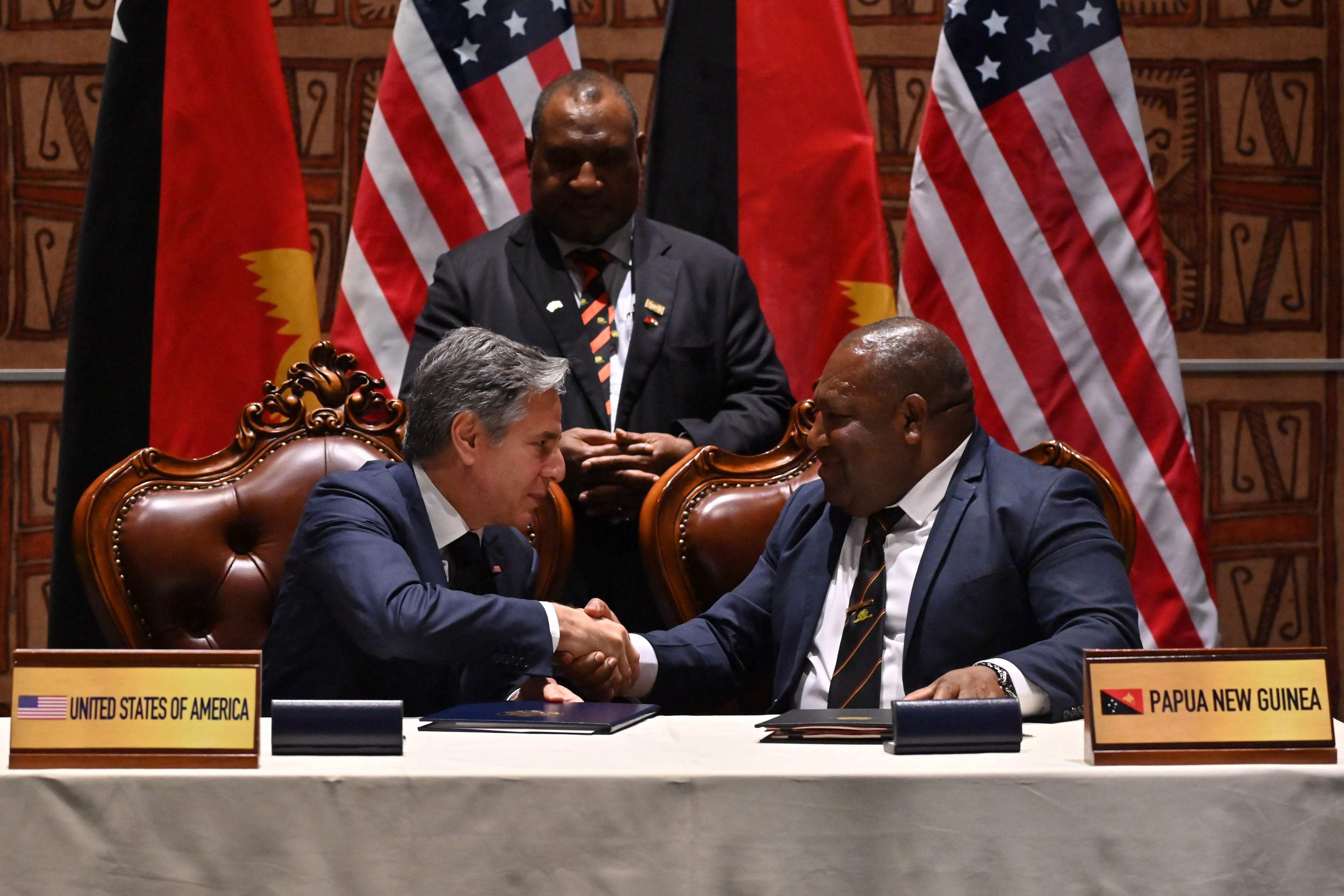 US Secretary of State Antony Blinken (left) and Papua New Guinea Defence Minister Win Bakri Daki shake hands after signing a security agreement as PNG Prime Minister James Marape looks on, in Port Moresby, on May 22. Photo: AFP