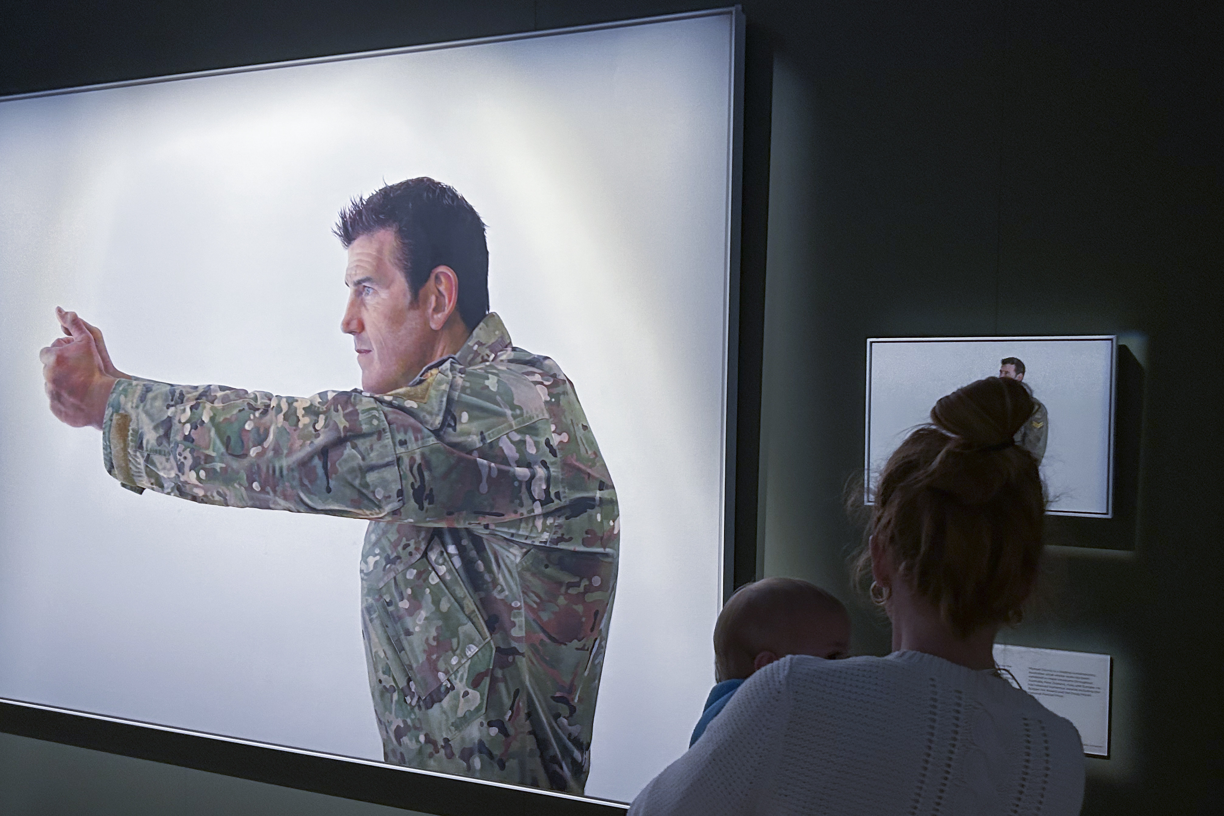 A visitor looks at a display featuring decorated war veteran Ben Roberts-Smith at the Australian War Memorial on Friday. In addition to the killing, he’d engaged in a “campaign of bullying” against another soldier, the judge said, including threatening “a bullet in the back of the head”. Photo: AP